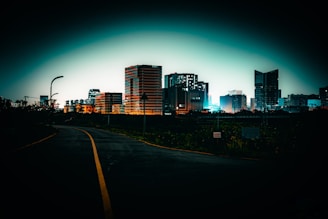 A road leads to a city at night.