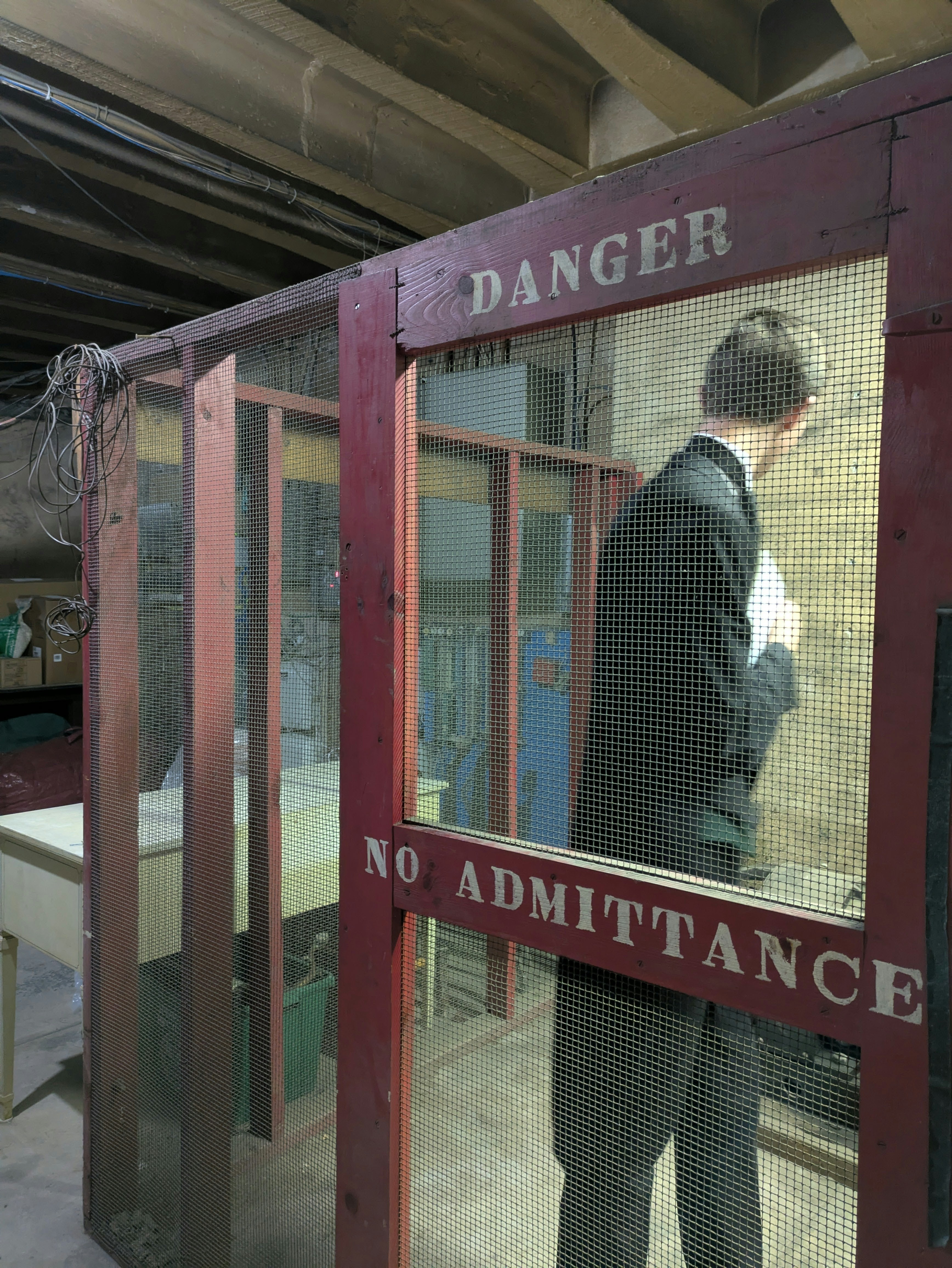 Un homme jette un coup d’œil dans une pièce « danger, interdiction d’admission ».