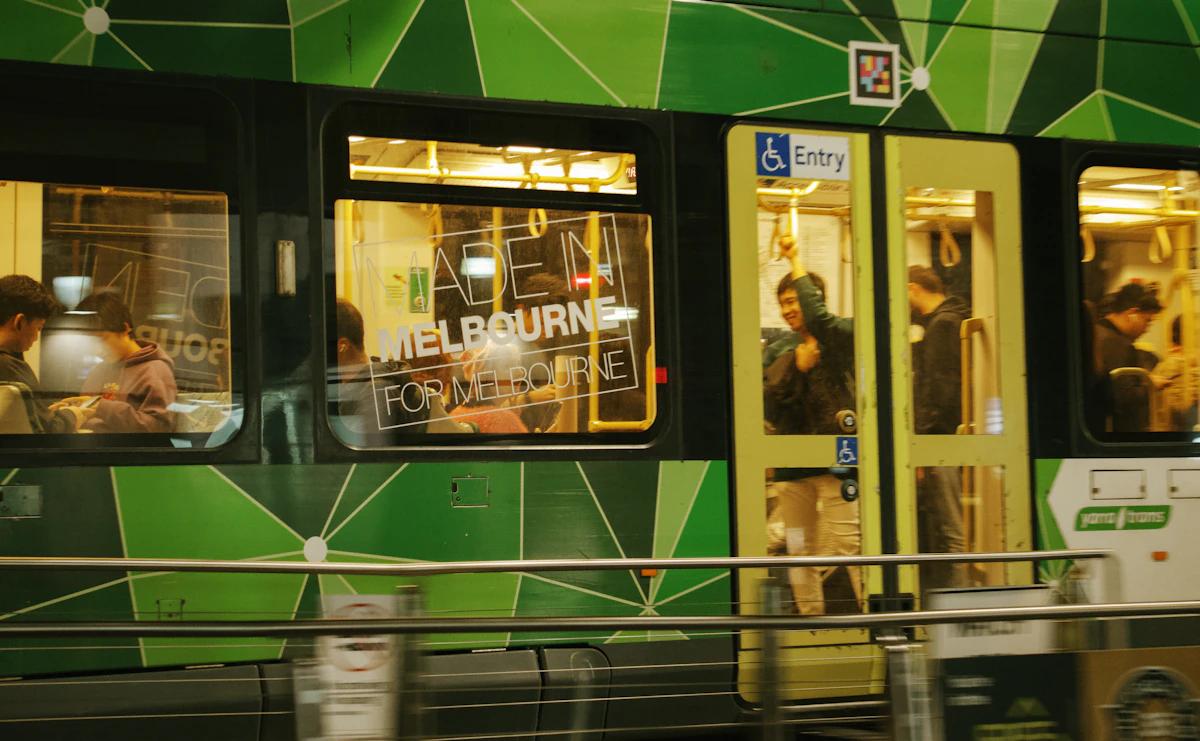 A green and orange tram travelling through central Melbourne