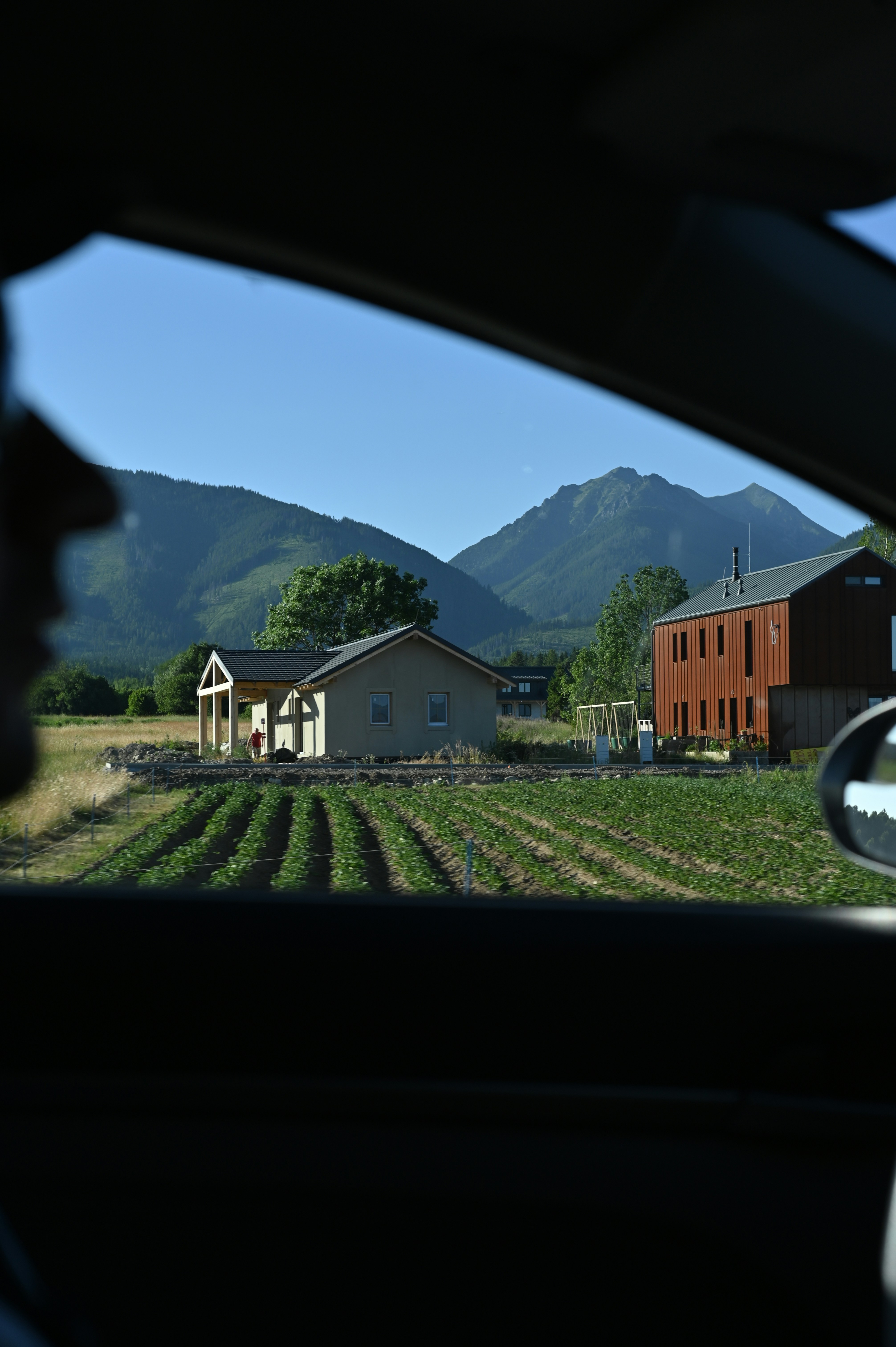 View from a car window of houses and mountains.