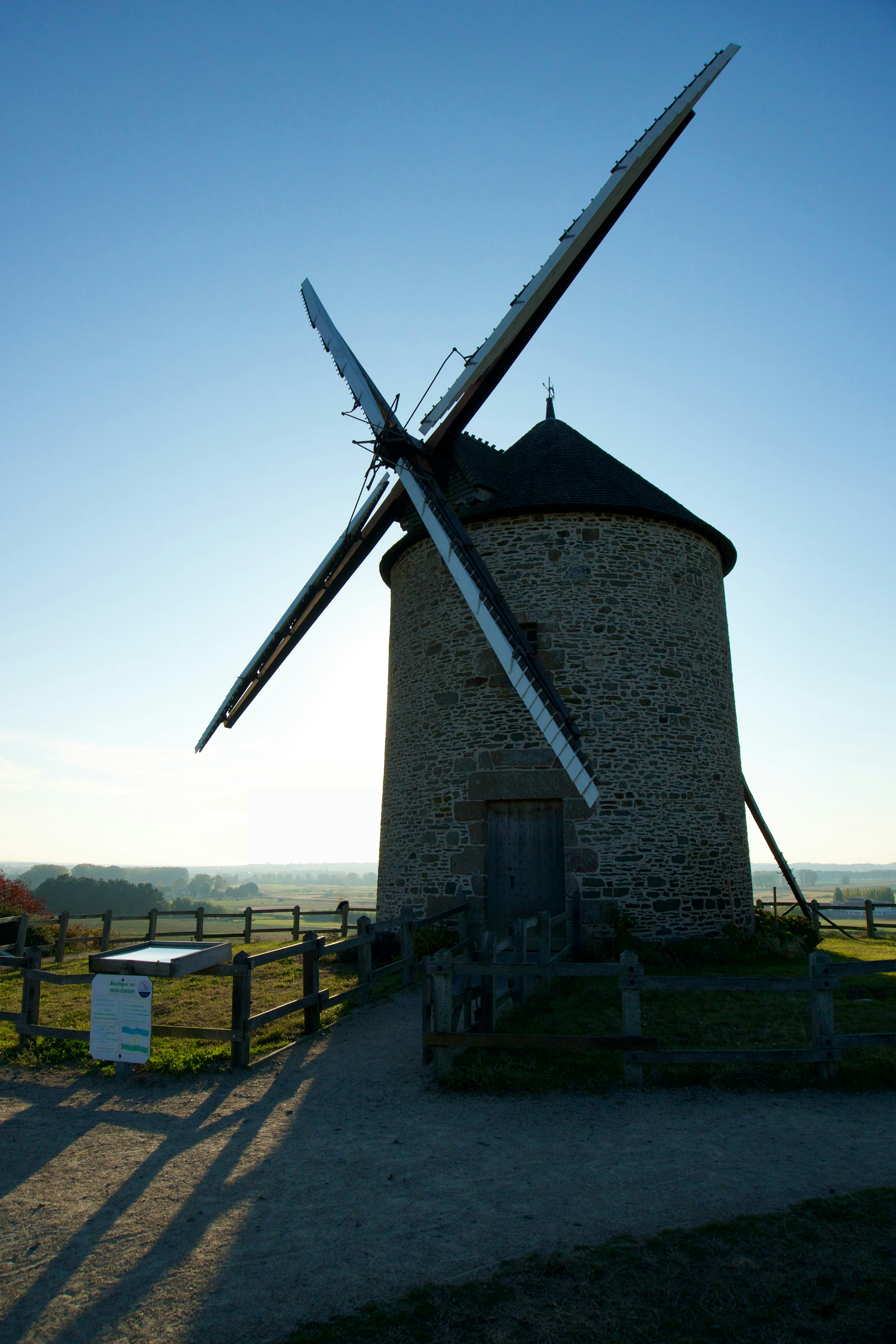An old windmill stands under the bright sun.