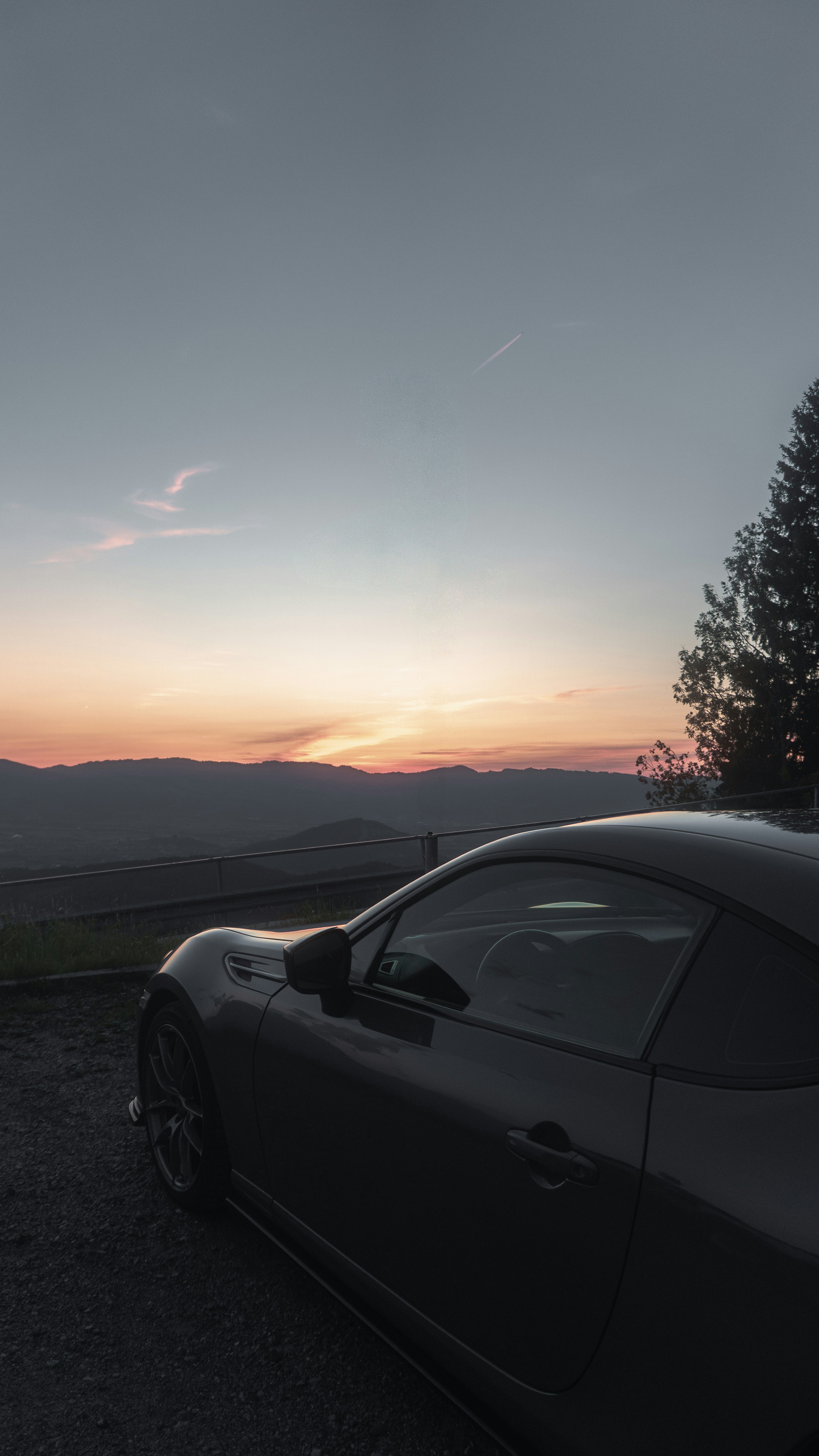 Car parked at sunset with a beautiful view.