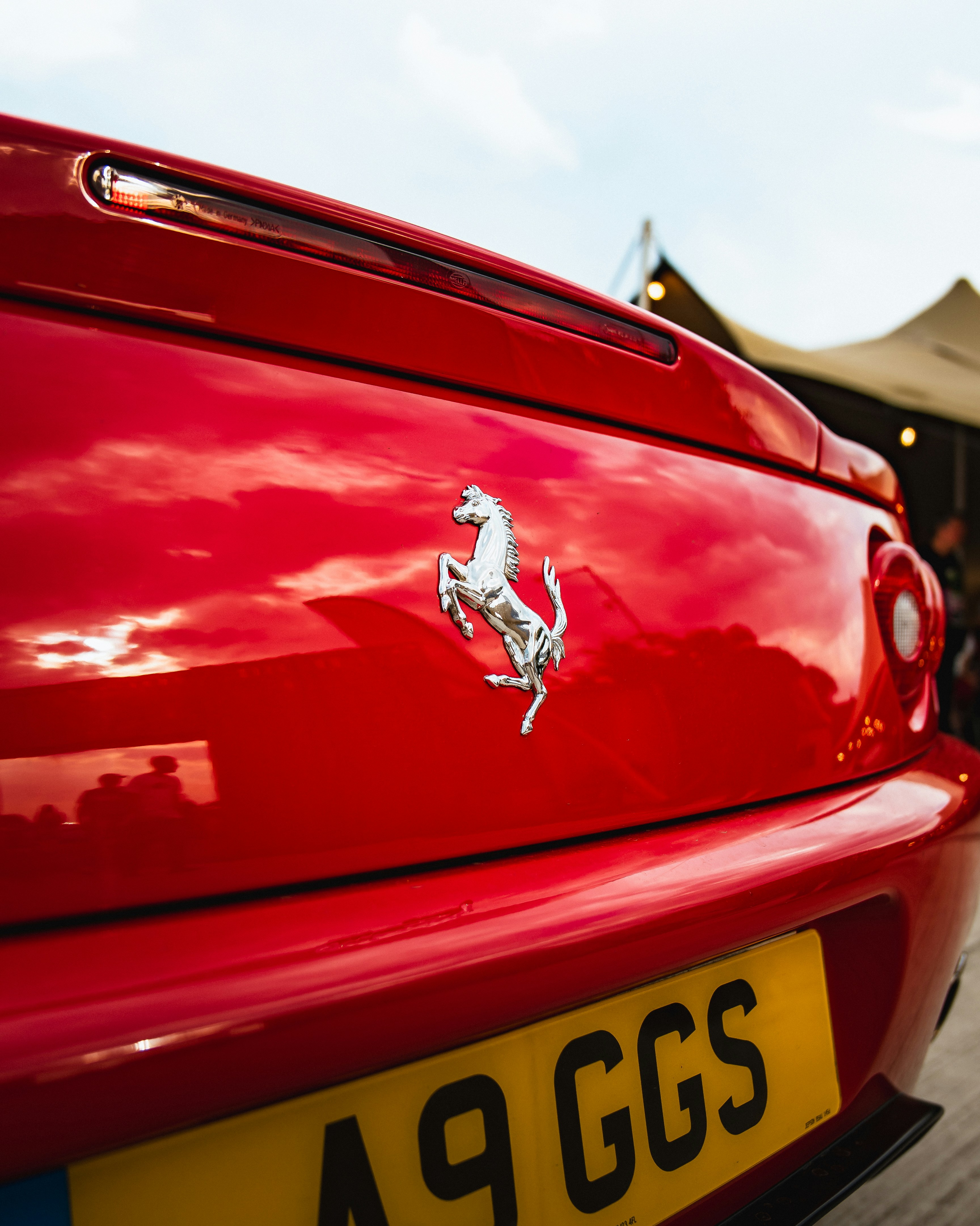 Red ferrari's rear with its classic logo.