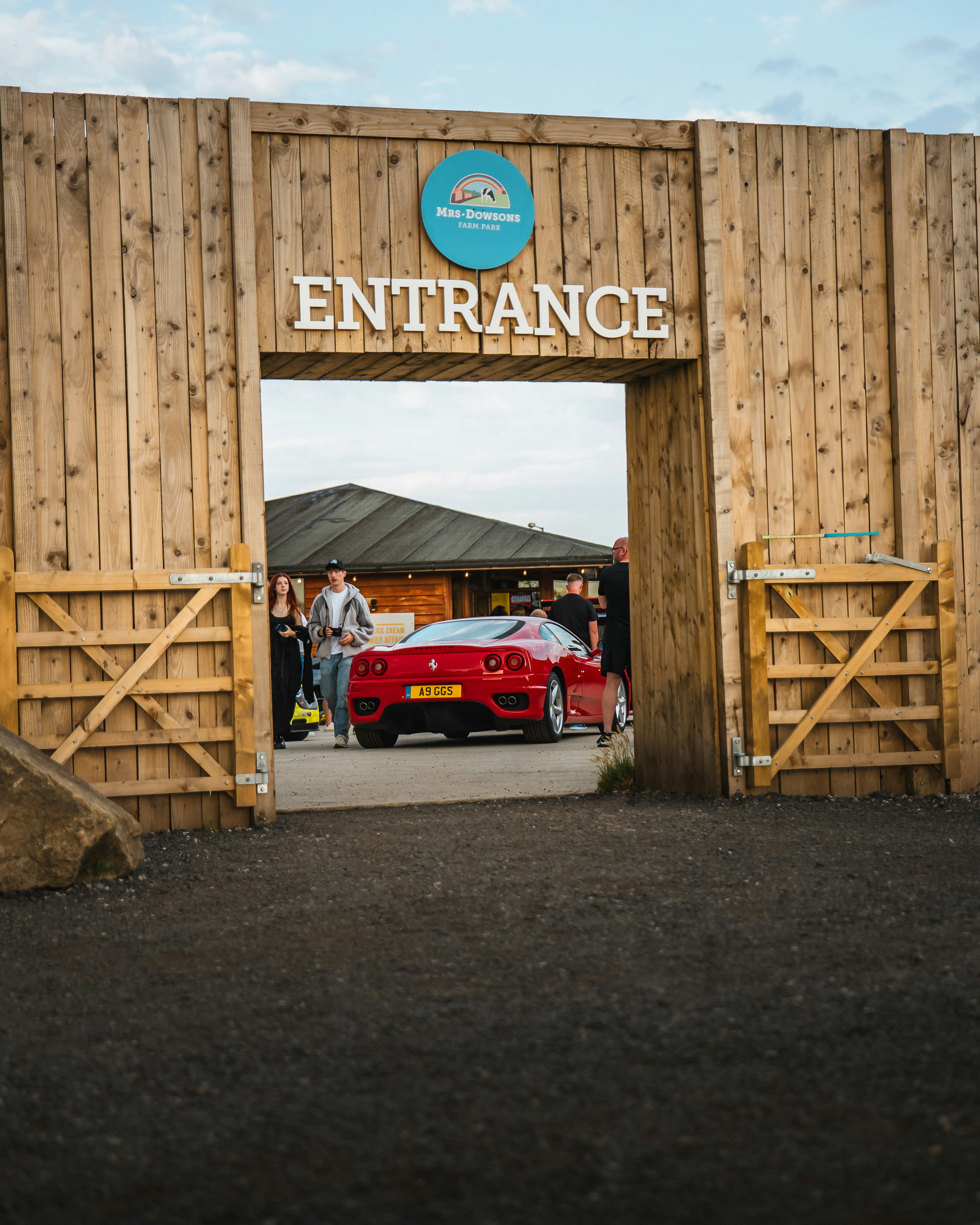 A red car approaches an entrance.