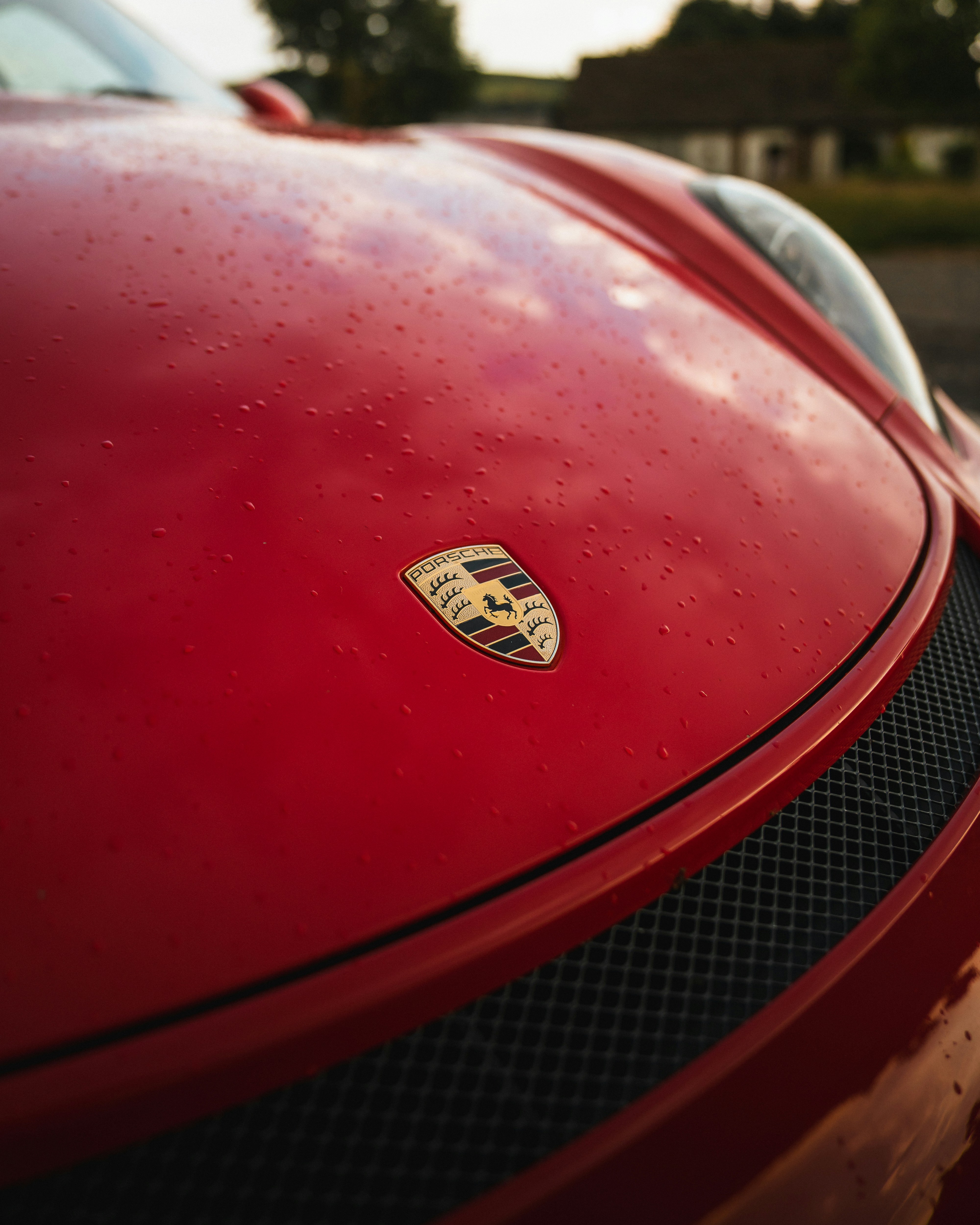 A red porsche shows off its emblem.