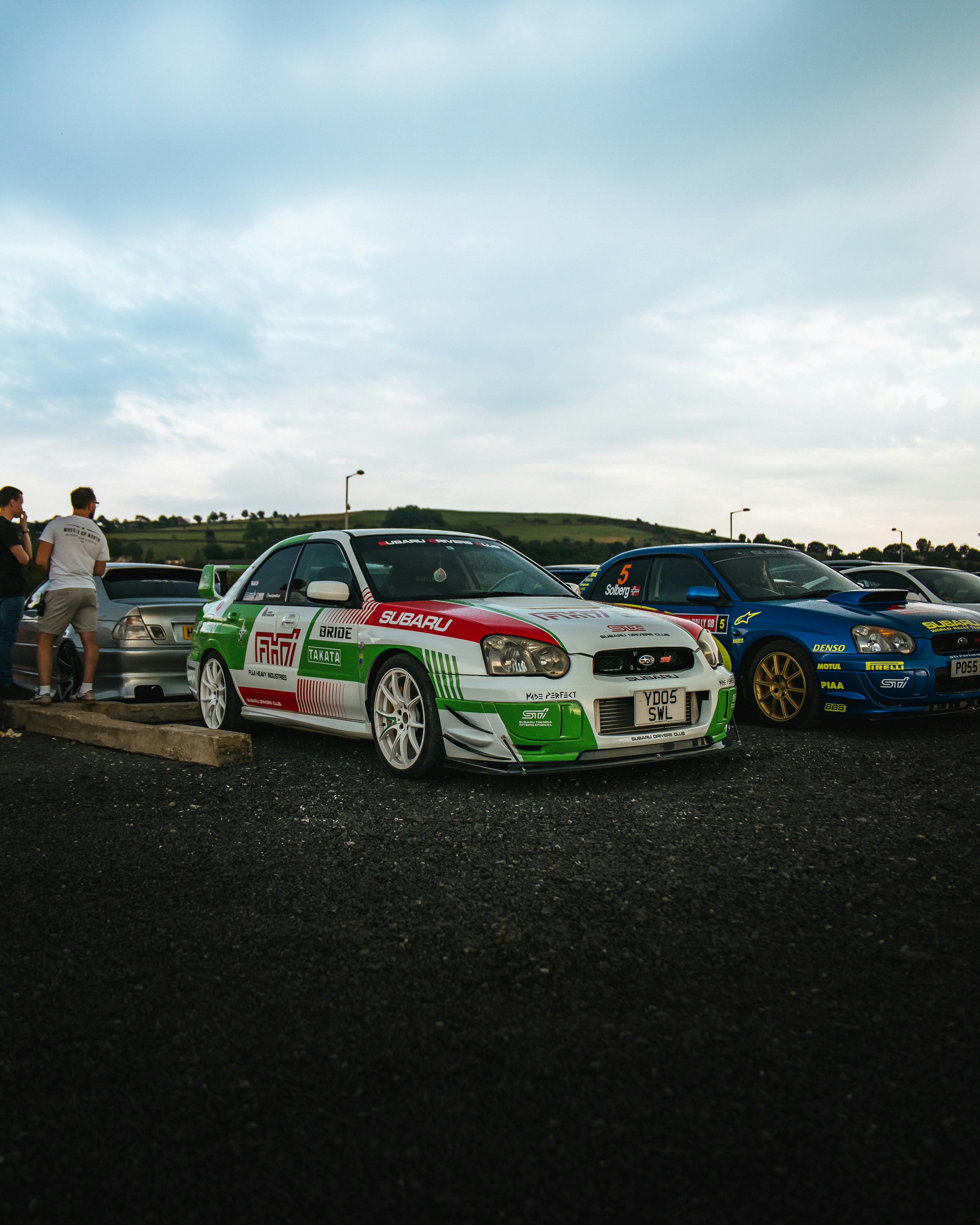Race cars lined up in a parking lot.