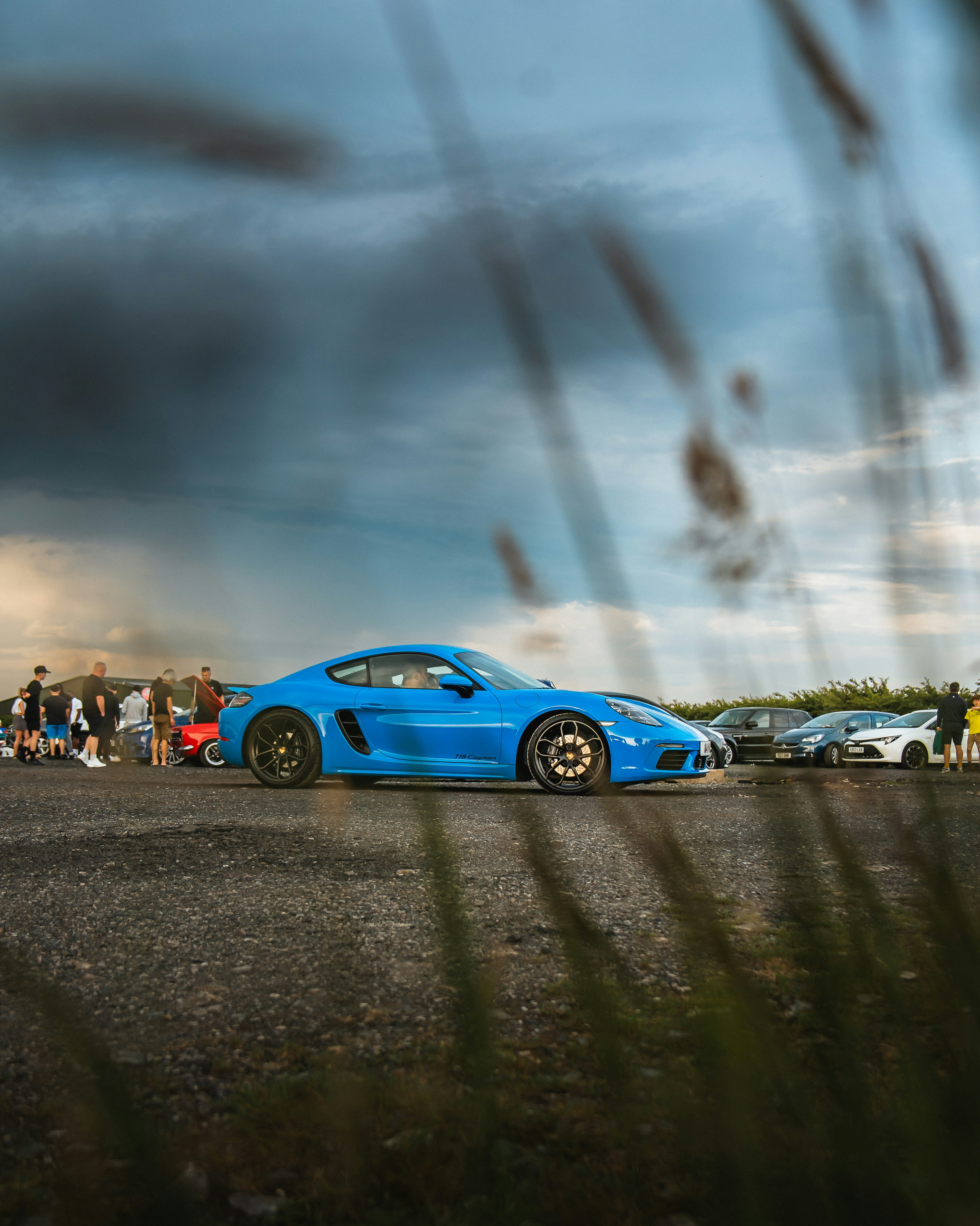 Un'auto sportiva blu a un raduno automobilistico.
