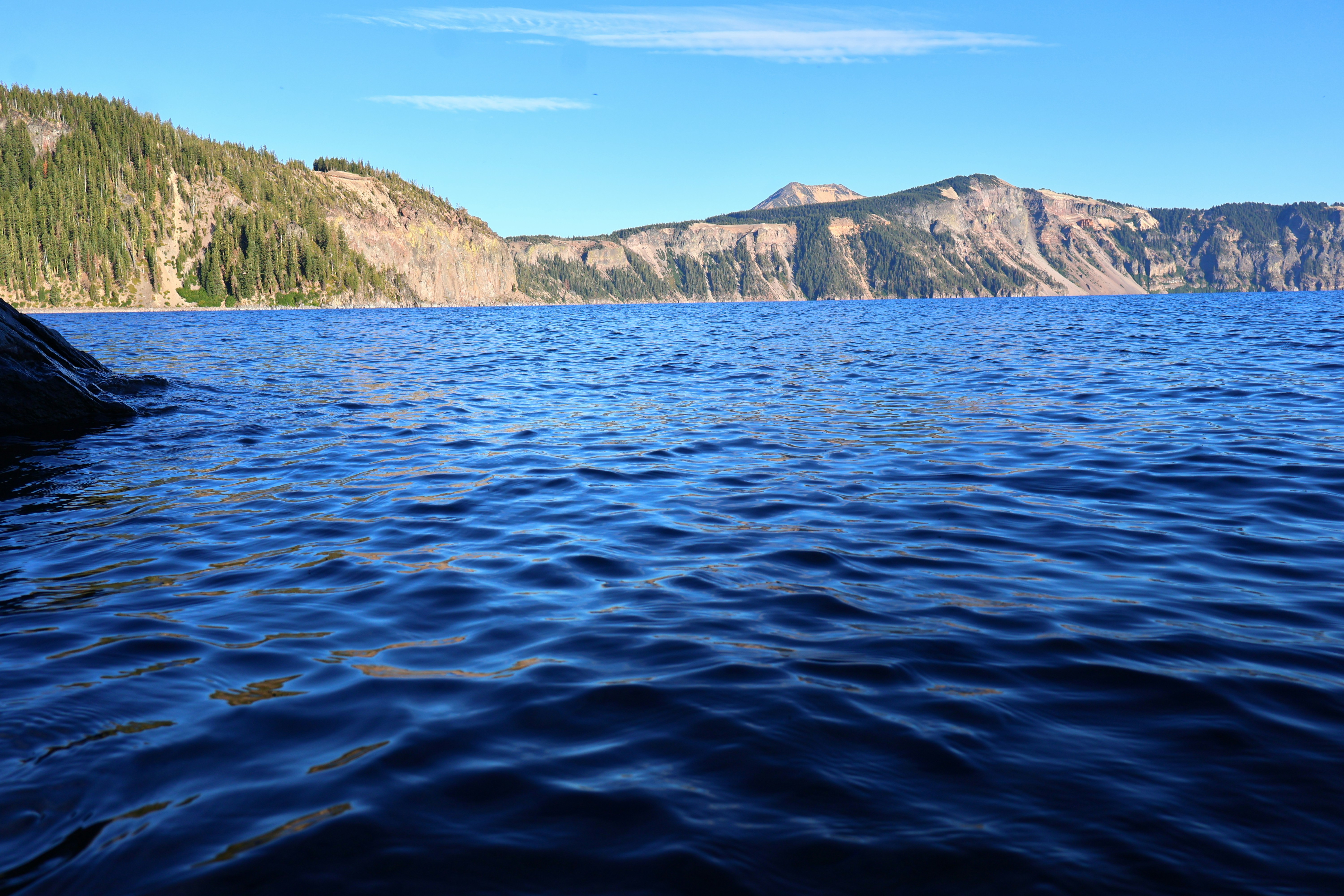 Blue lake with mountains and a clear sky.