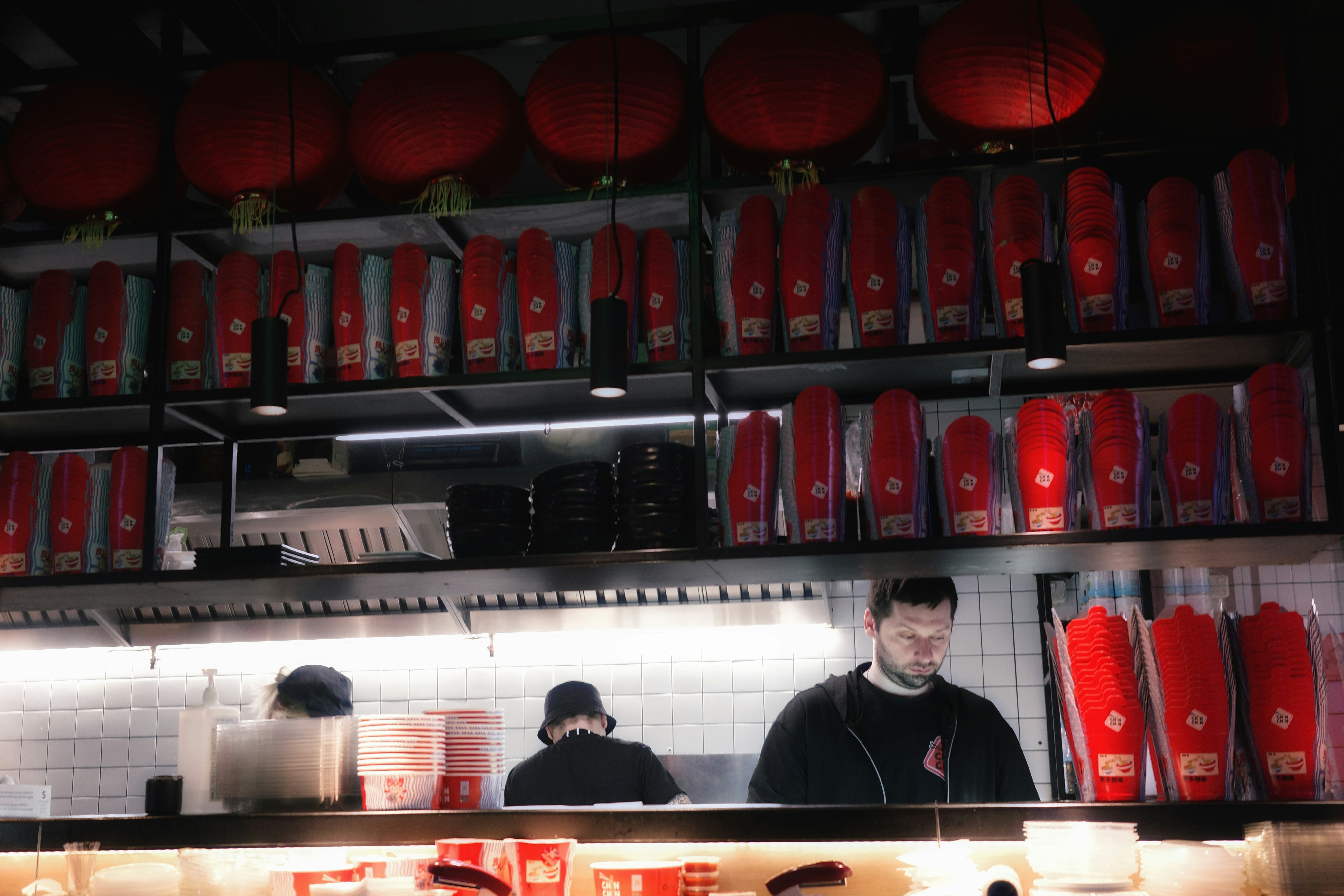 People work behind a counter at a restaurant.