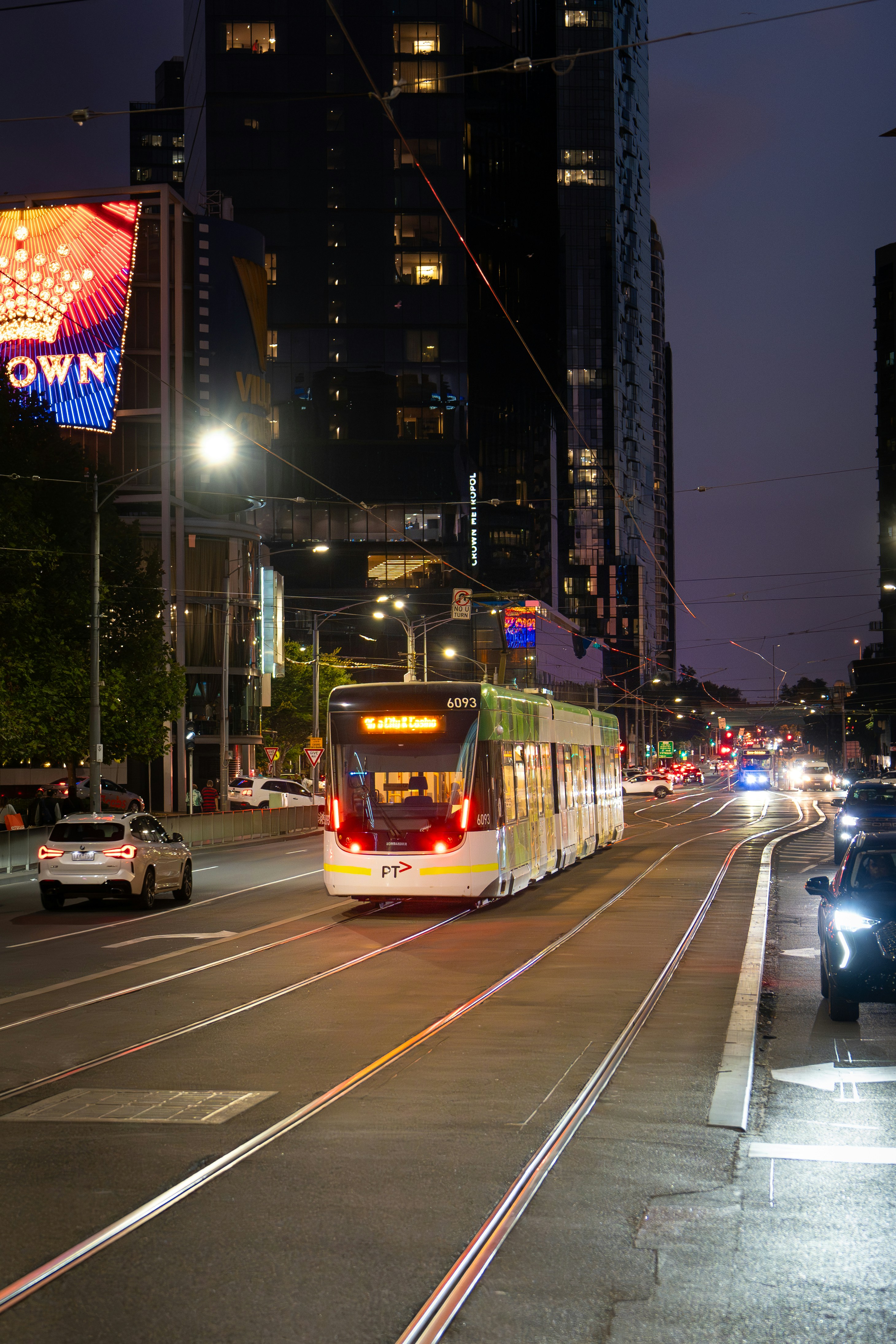 A tram travels down a city street at night.