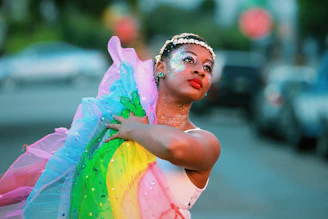 A dancer poses with rainbow-colored fabric.