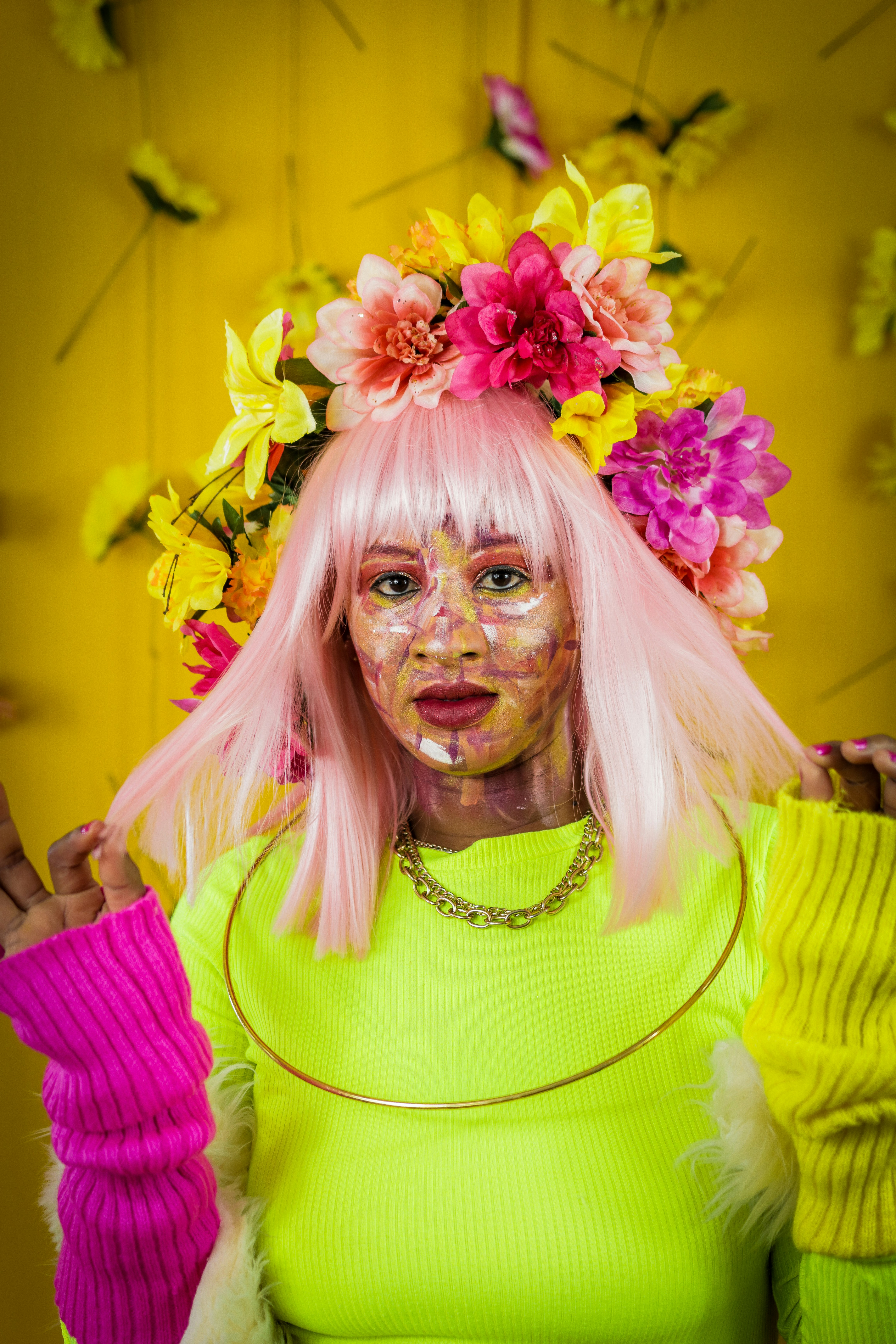 Woman with floral crown and bright makeup poses.