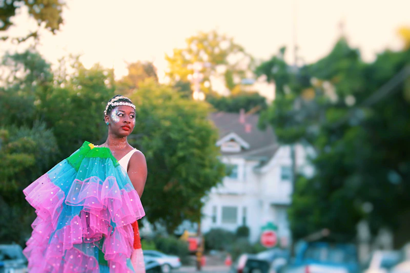 Femboy with colorful garb stands on the street