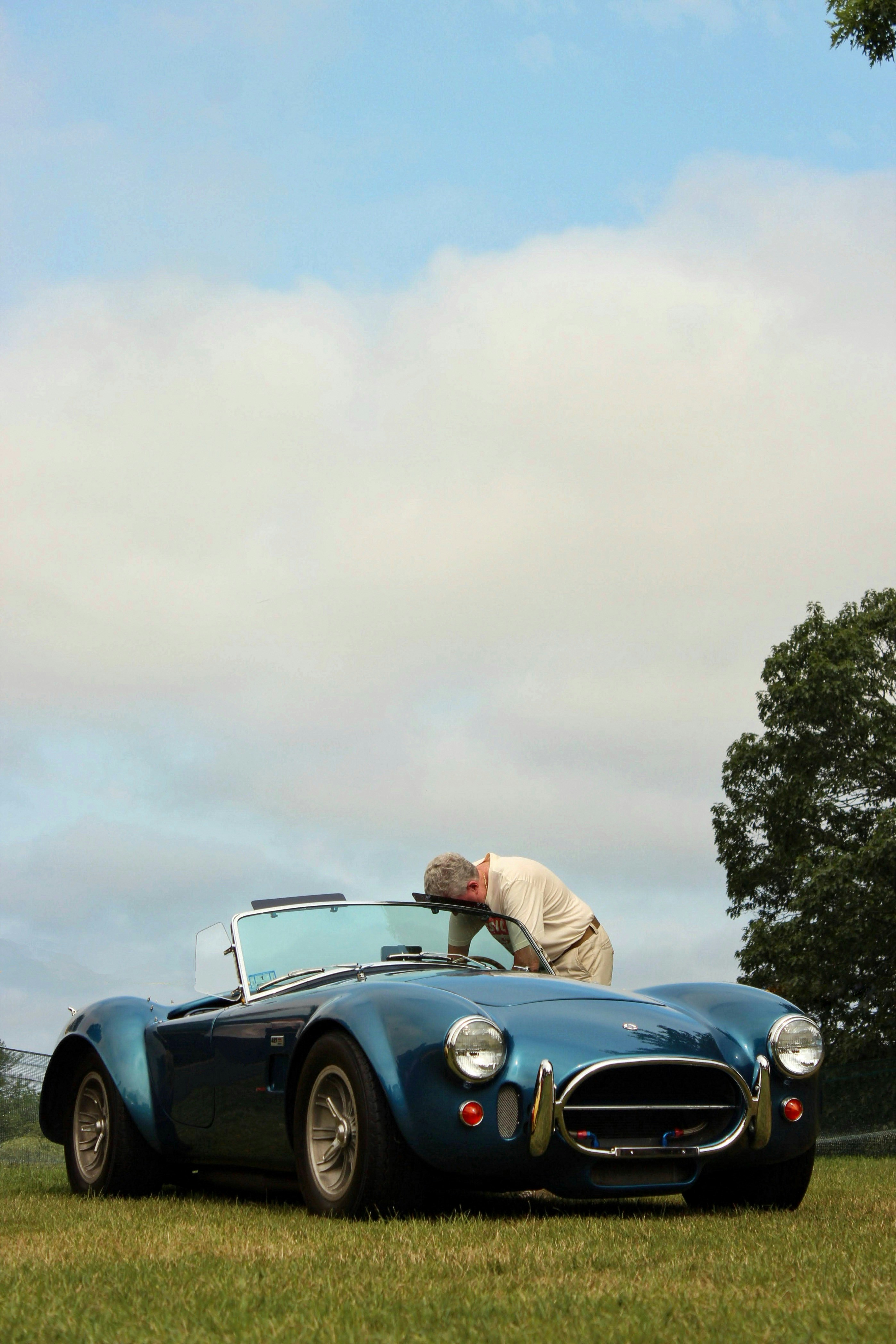 男は美しい青いクラシックカーを賞賛します。の写真 – Unsplashの車の