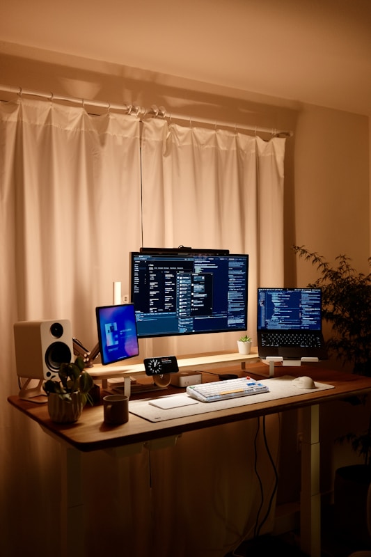 Professional AI consulting home office workspace with multiple screens displaying client projects and revenue tracking