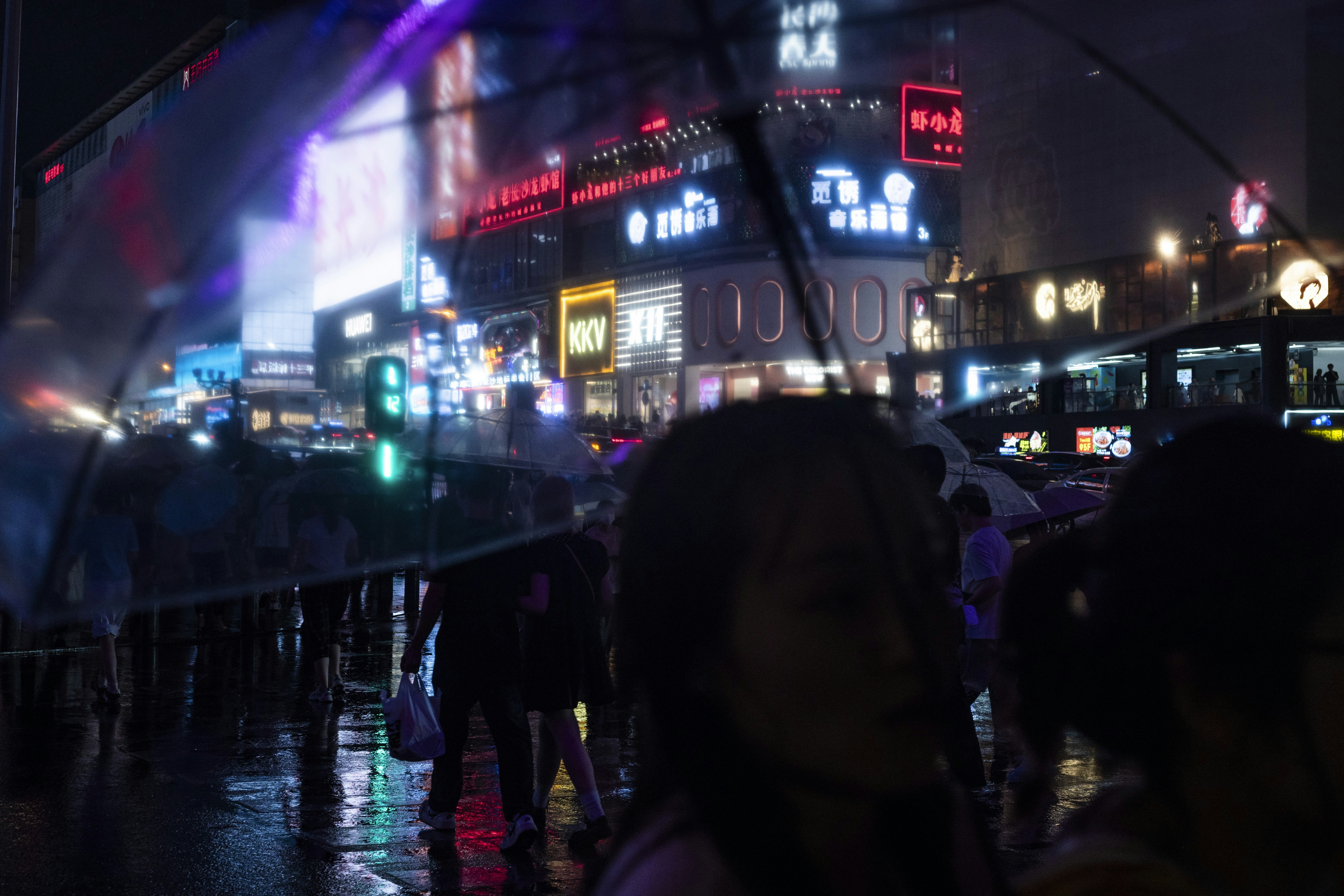 Rainy night in a vibrant, bustling city.