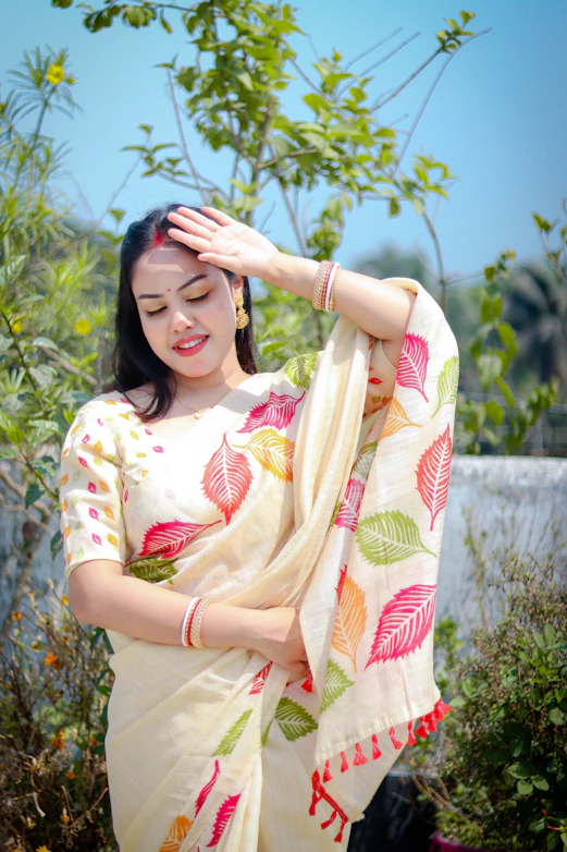 A woman poses in a beautiful, leaf-printed saree.