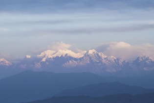 Snow-capped mountains under a beautiful, cloudy sky.