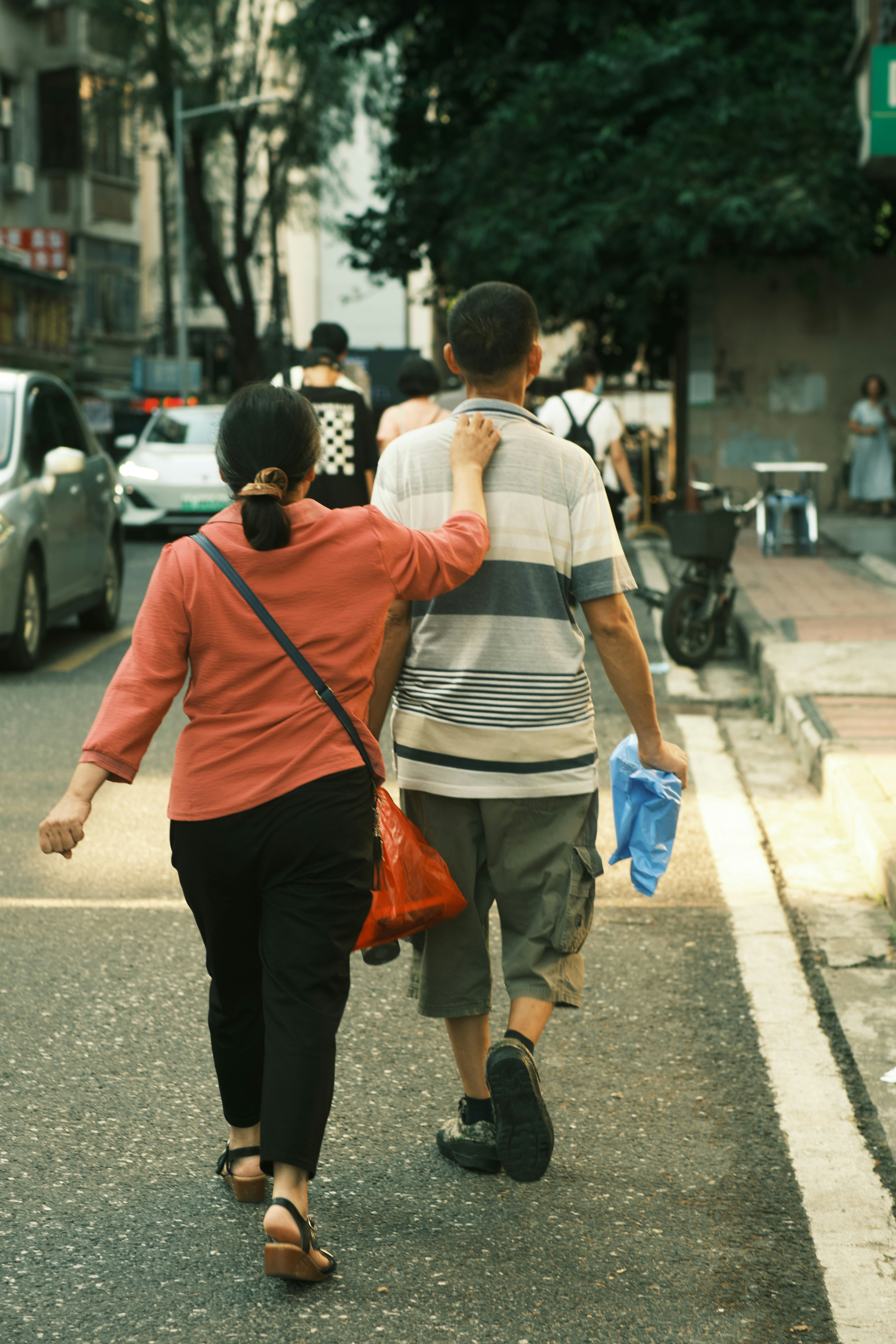 A couple walks down a city street together.
