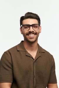Smiling man with glasses poses for a portrait.
