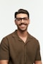 Smiling man with glasses poses for a portrait.