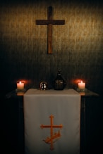 A wooden cross hangs above a religious altar.