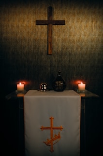 A wooden cross hangs above a religious altar.