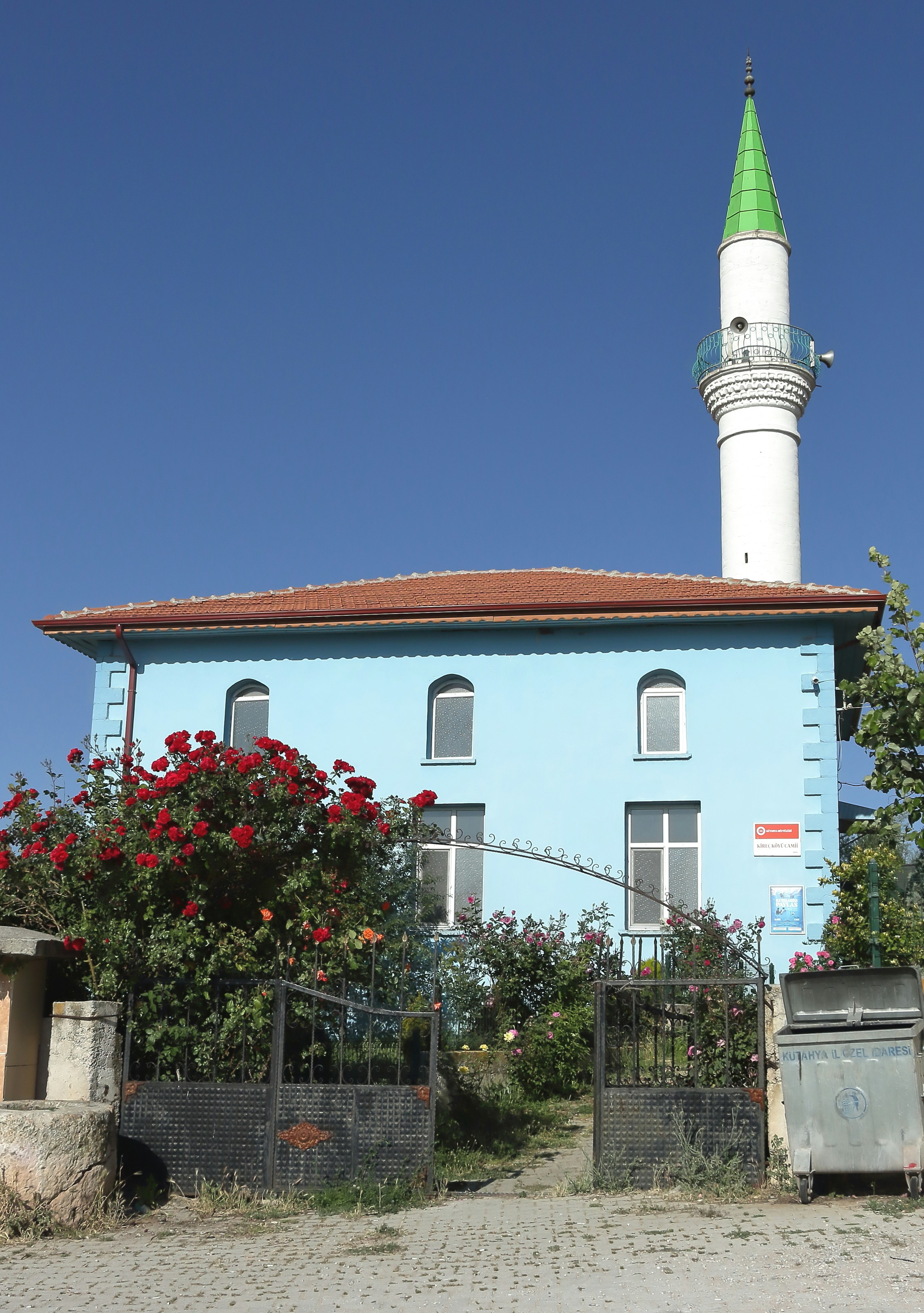 A blue mosque with a green minaret.