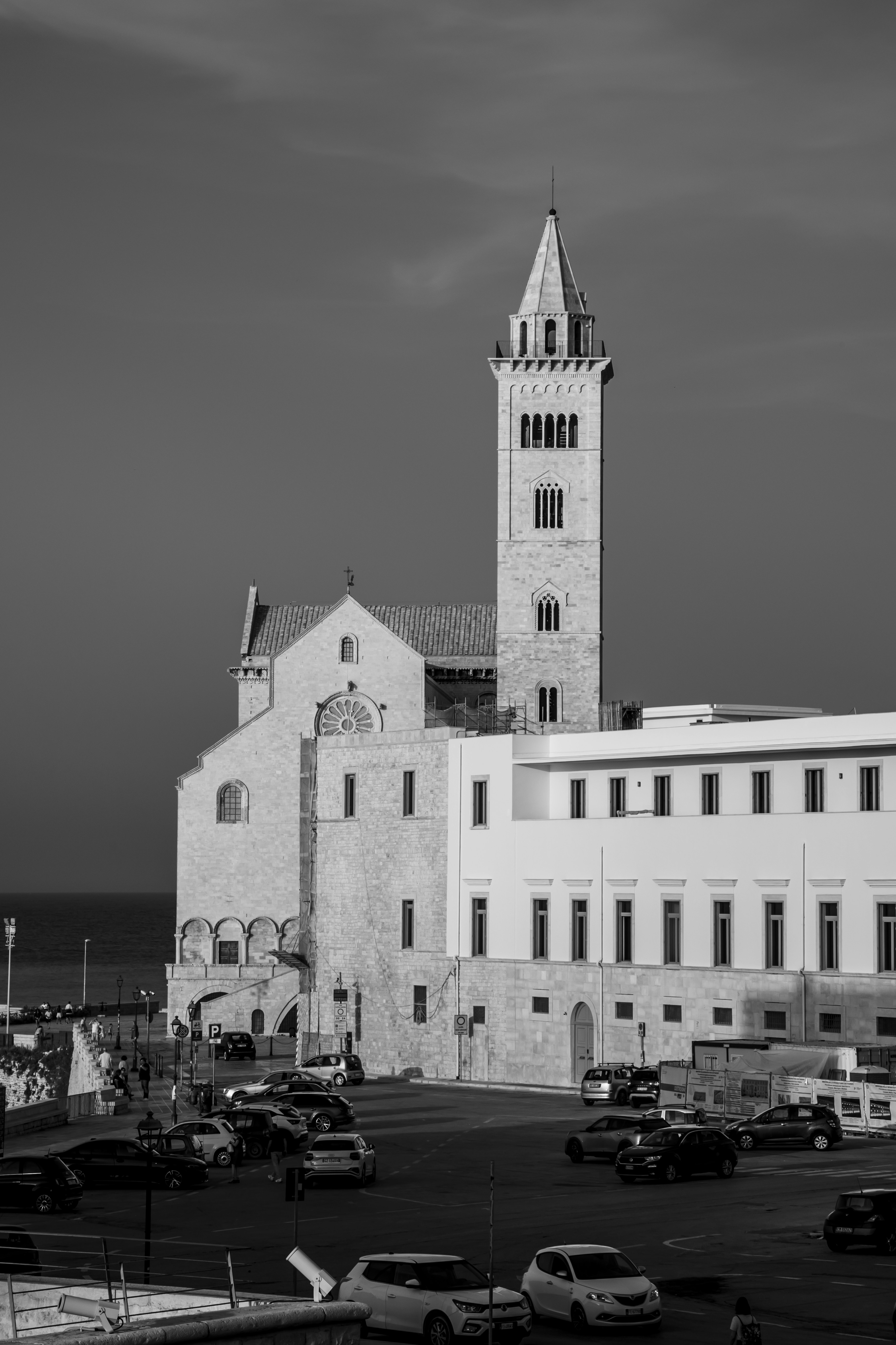 A church with a tall tower and cars below.