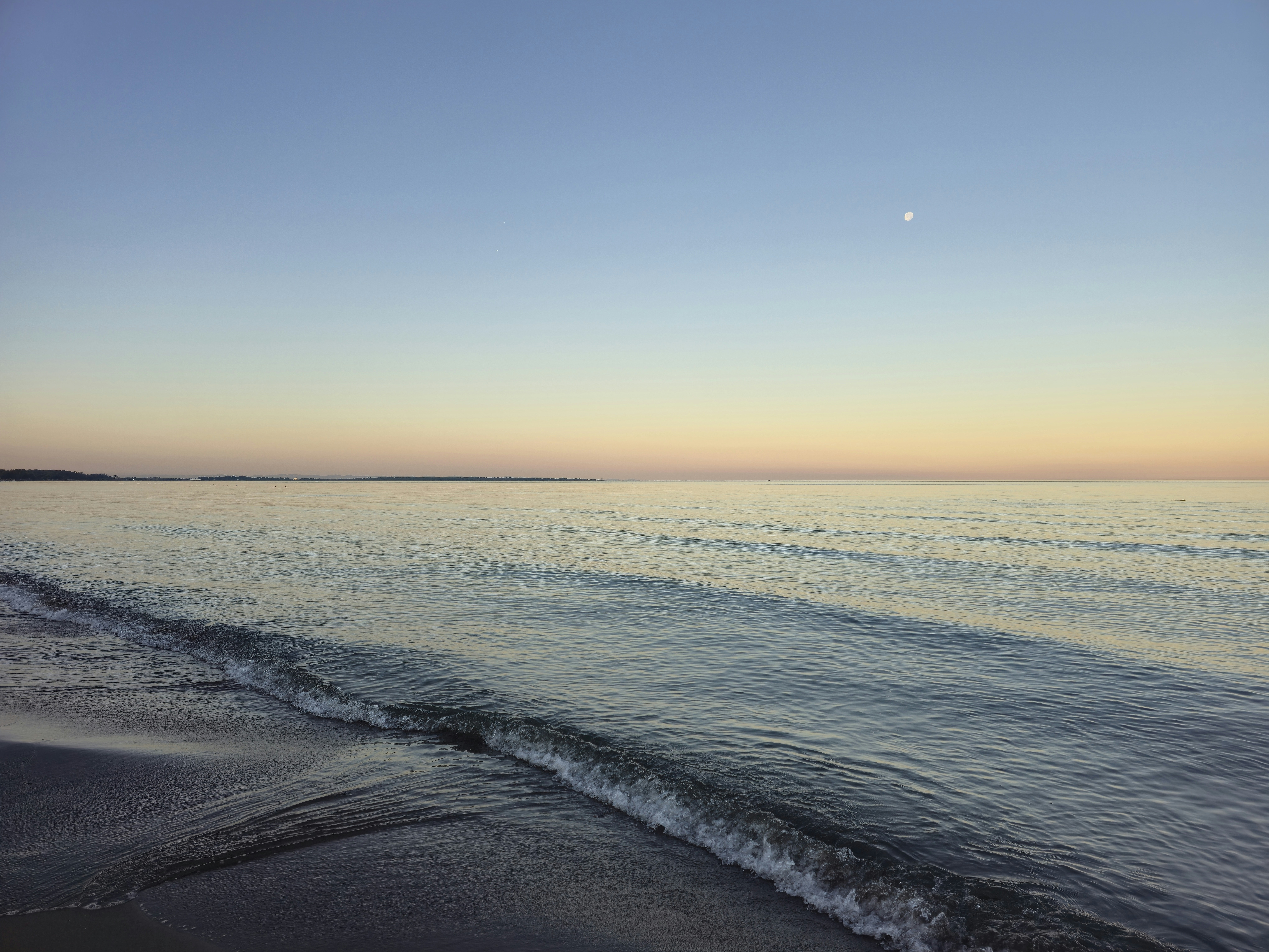 The serene ocean reflects the clear evening sky. photo – Free Beach Image  on Unsplash, image size:3000x2250