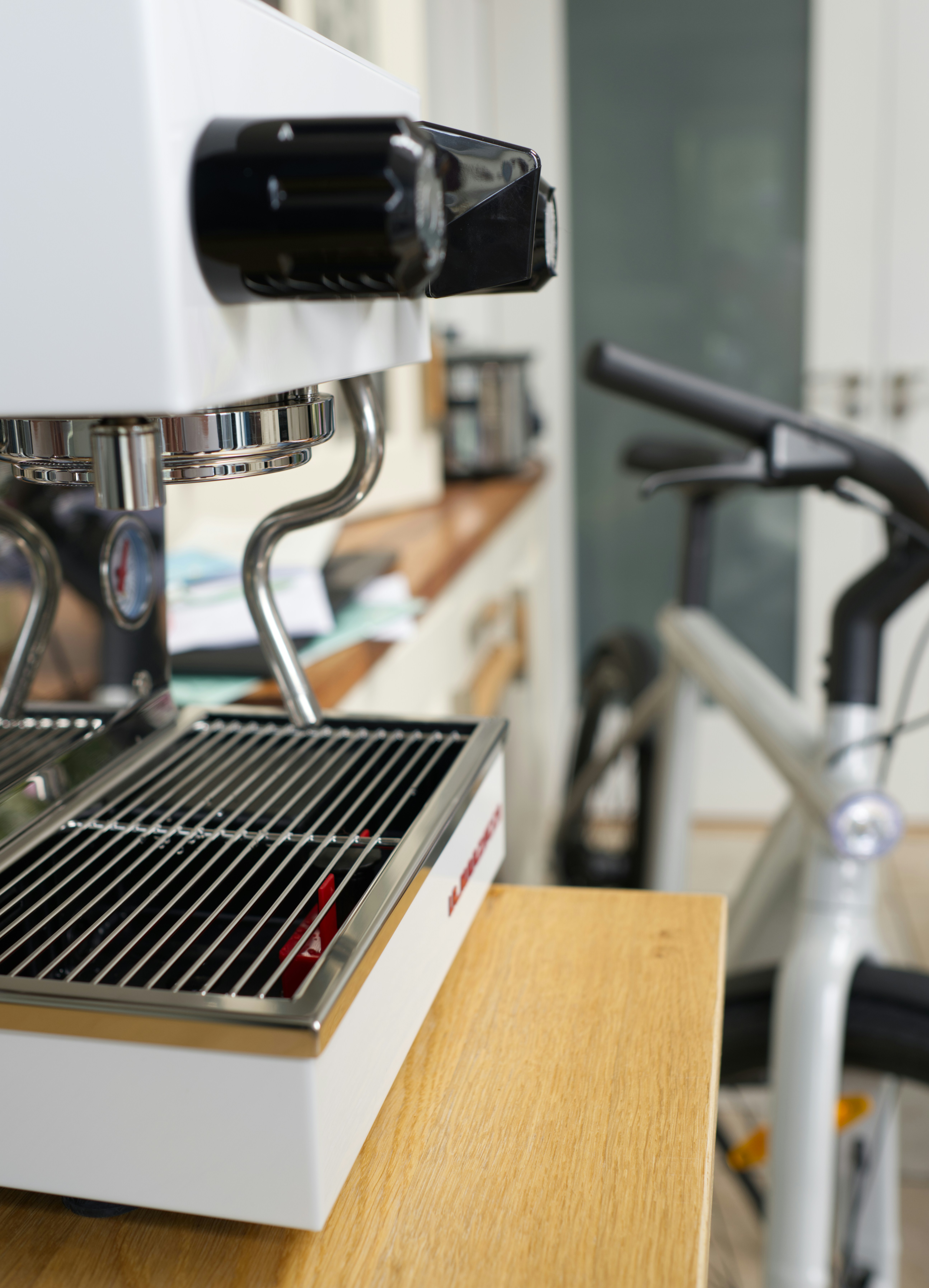Coffee machine on a counter with a bicycle.