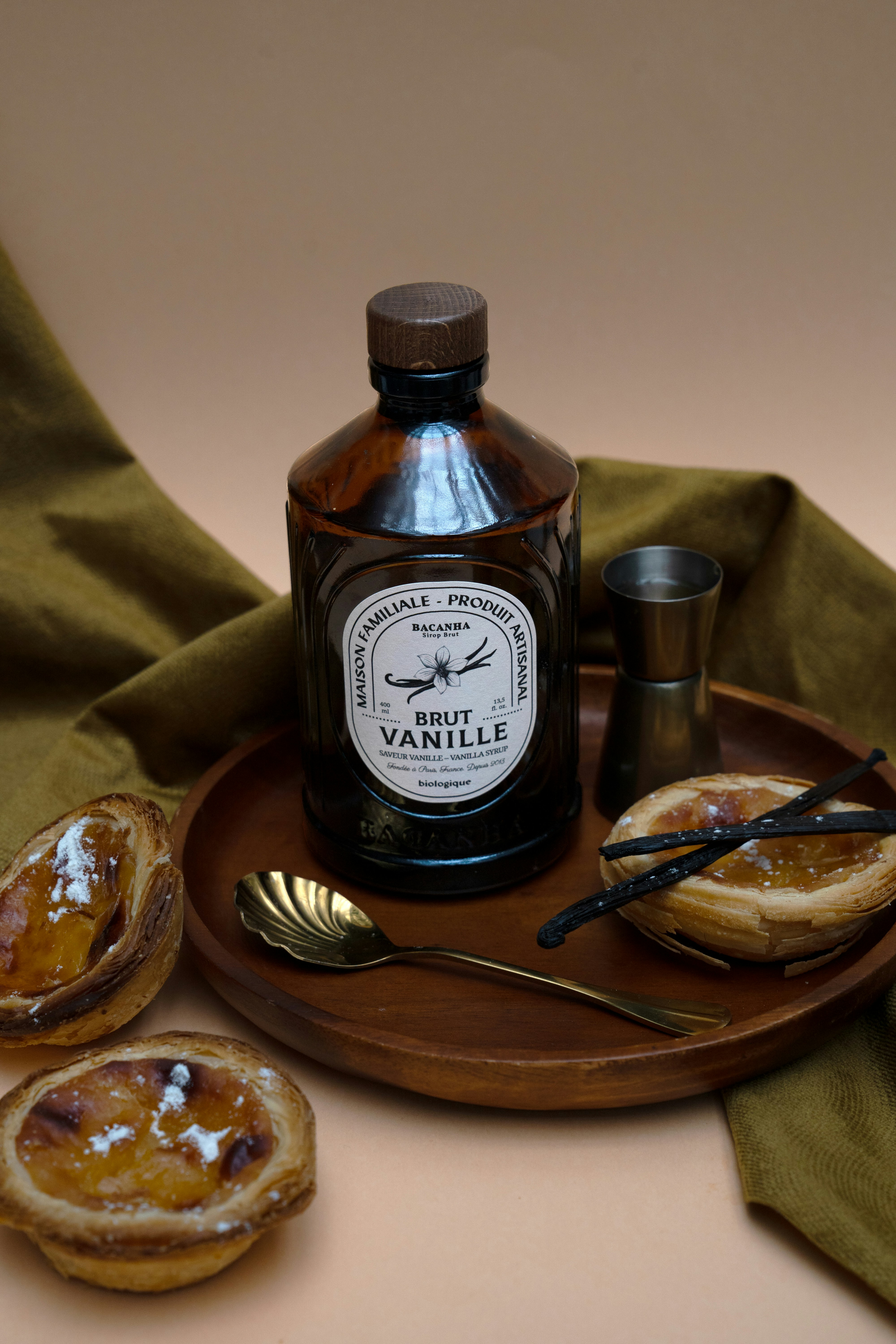 Vanilla extract, desserts, and utensils on a tray.