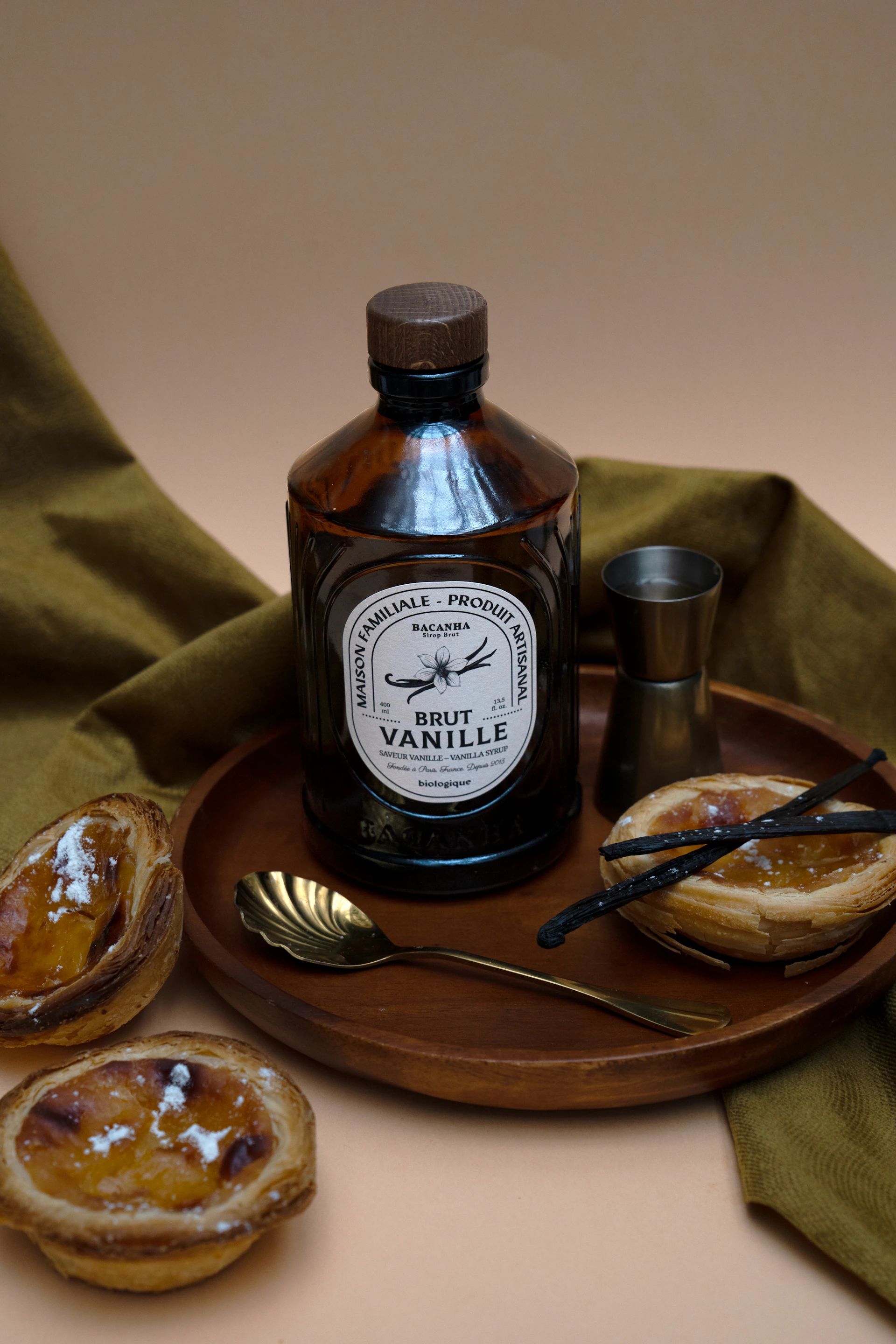 Vanilla extract, desserts, and utensils on a tray.