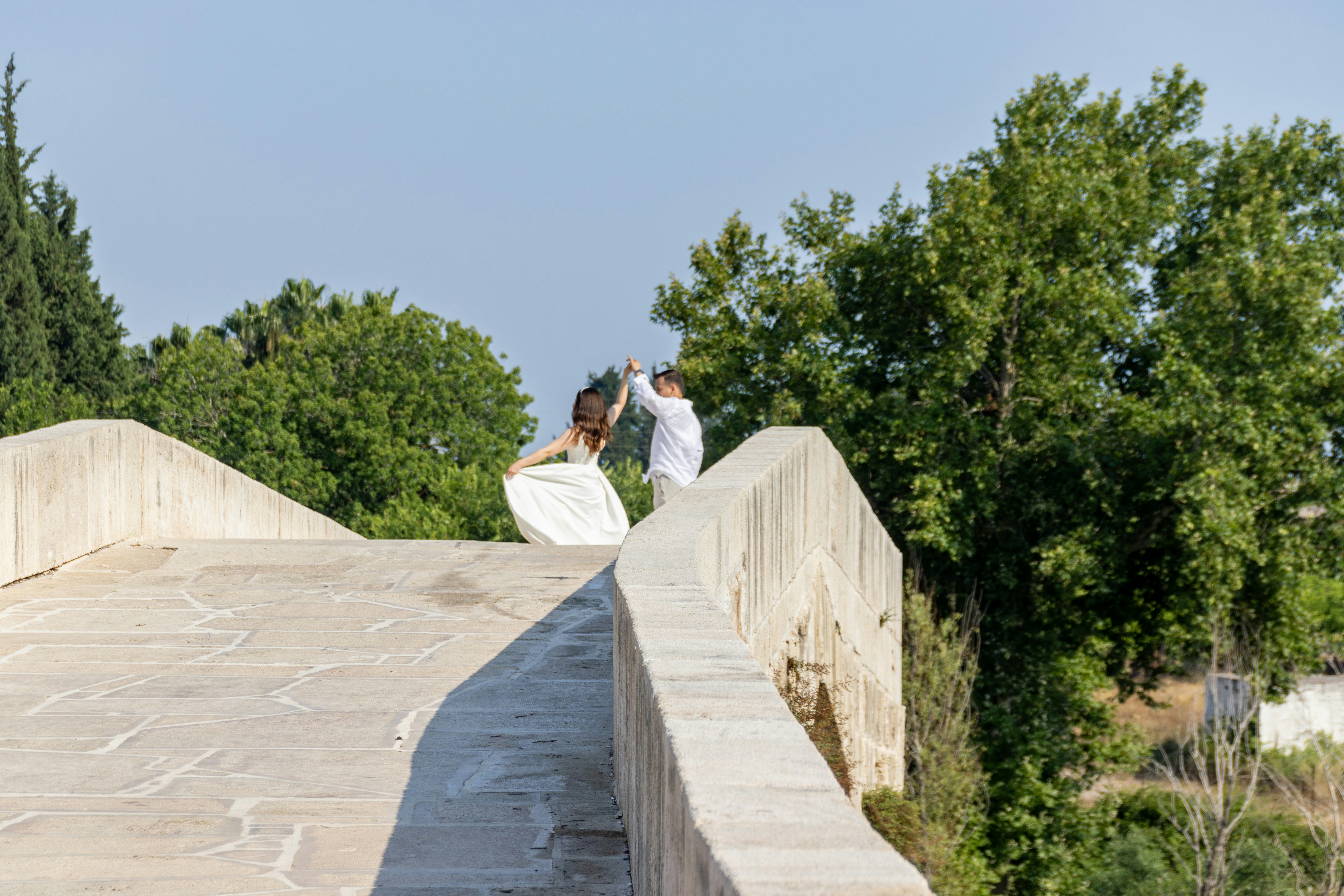 Una pareja baila alegremente en un puente.