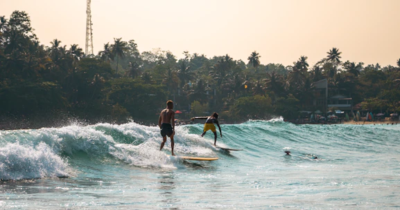Surfers ride waves in the ocean.
