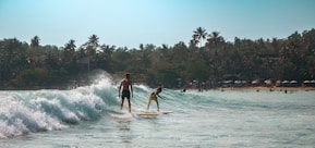 Two surfers ride a wave in the ocean.