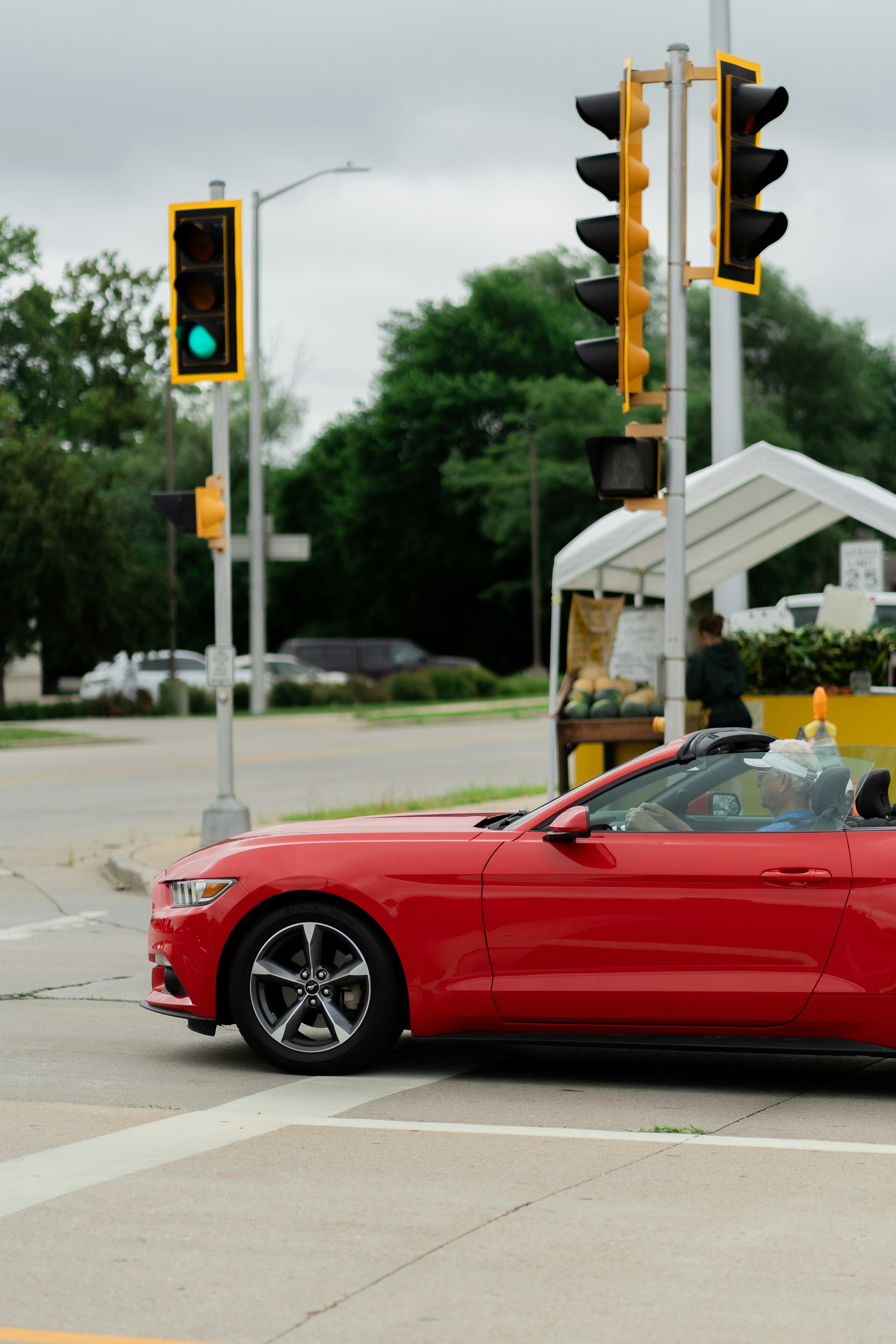 A red mustang waits at a traffic light.