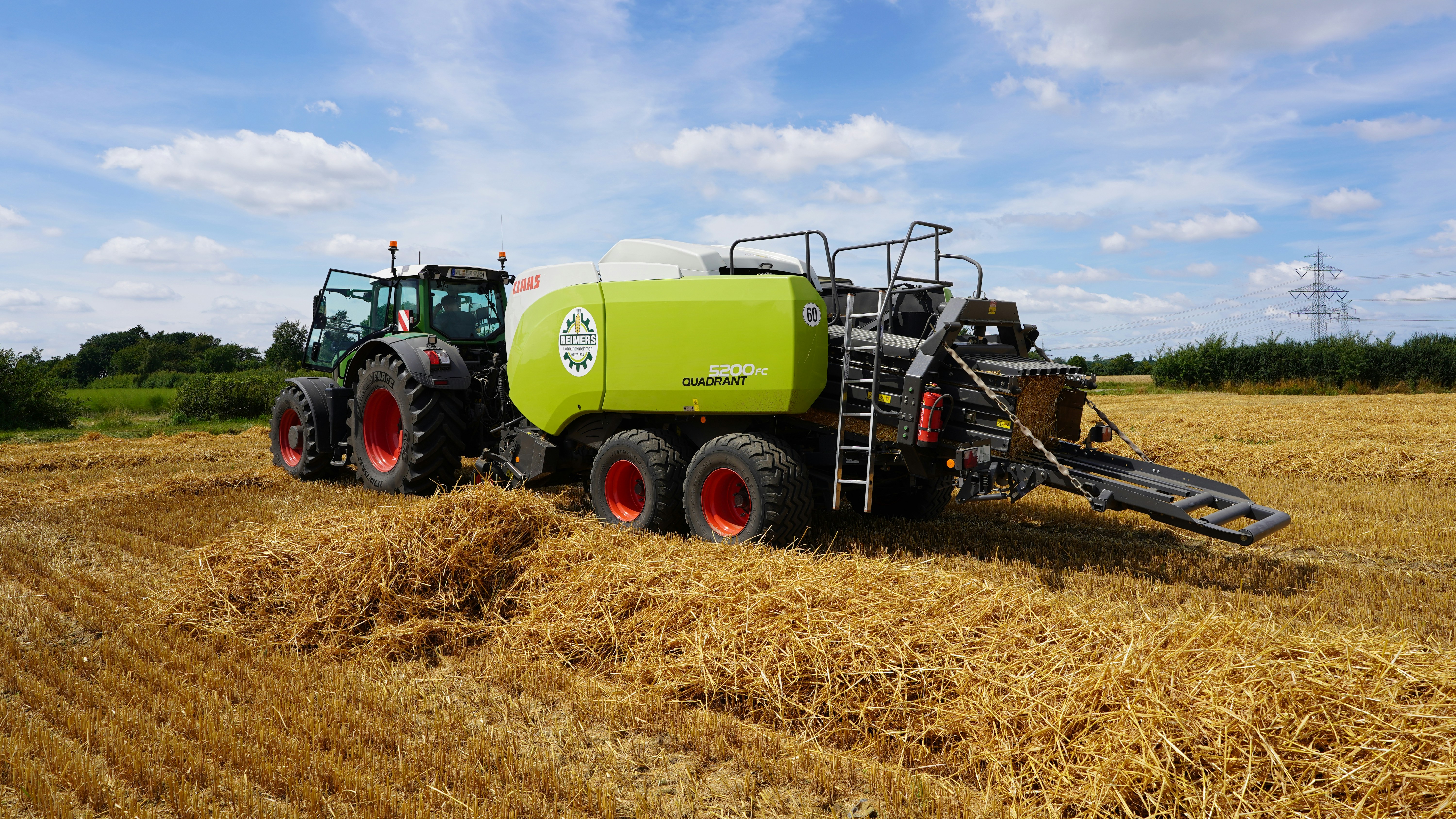 A tractor bales hay in a golden field.