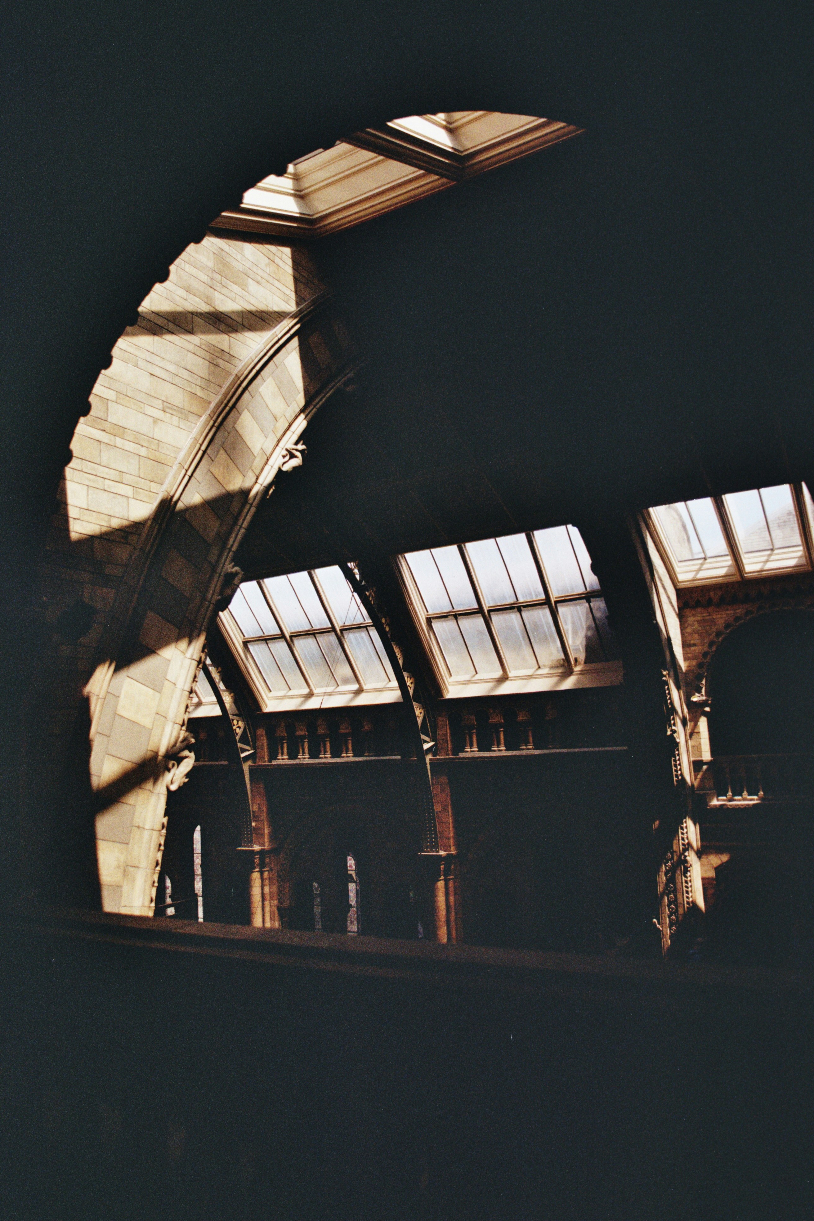 Arched windows illuminate a dark interior space.