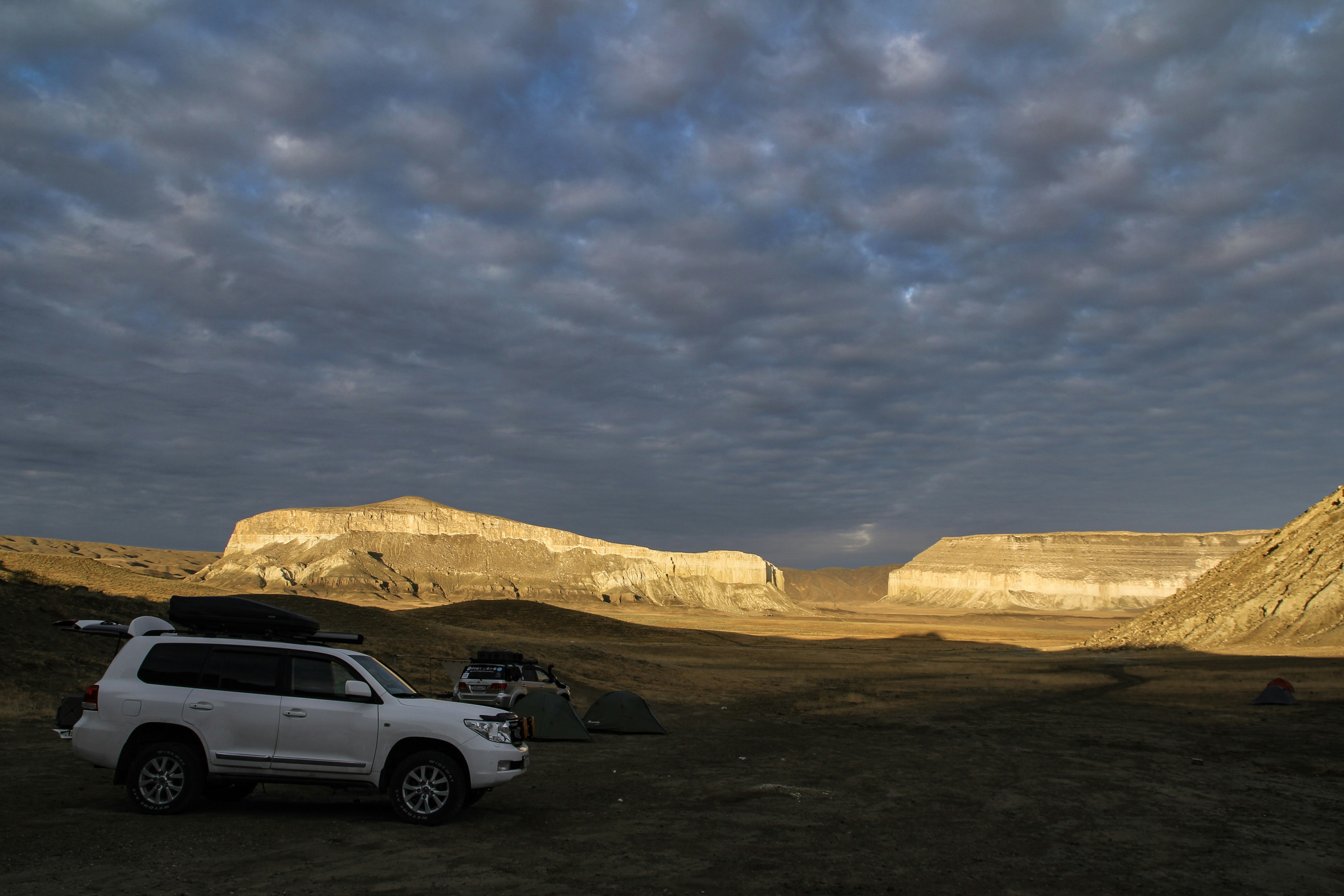 A white SUV parked in a picturesque desert landscape, ideal for exploring the surroundings of Aktau