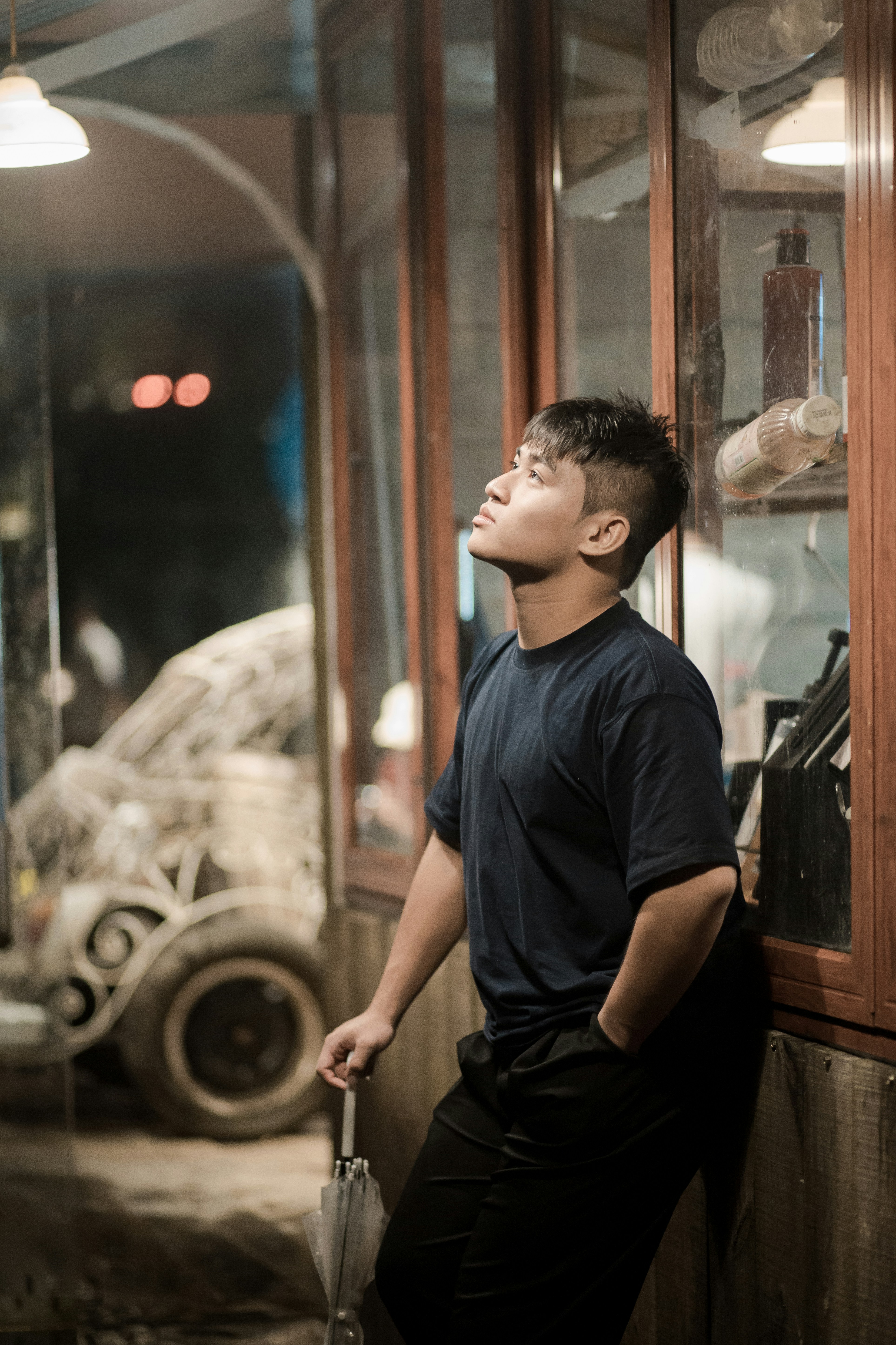 A man gazes upward, leaning on a wall.