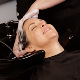 A woman enjoys a hair wash at a salon.