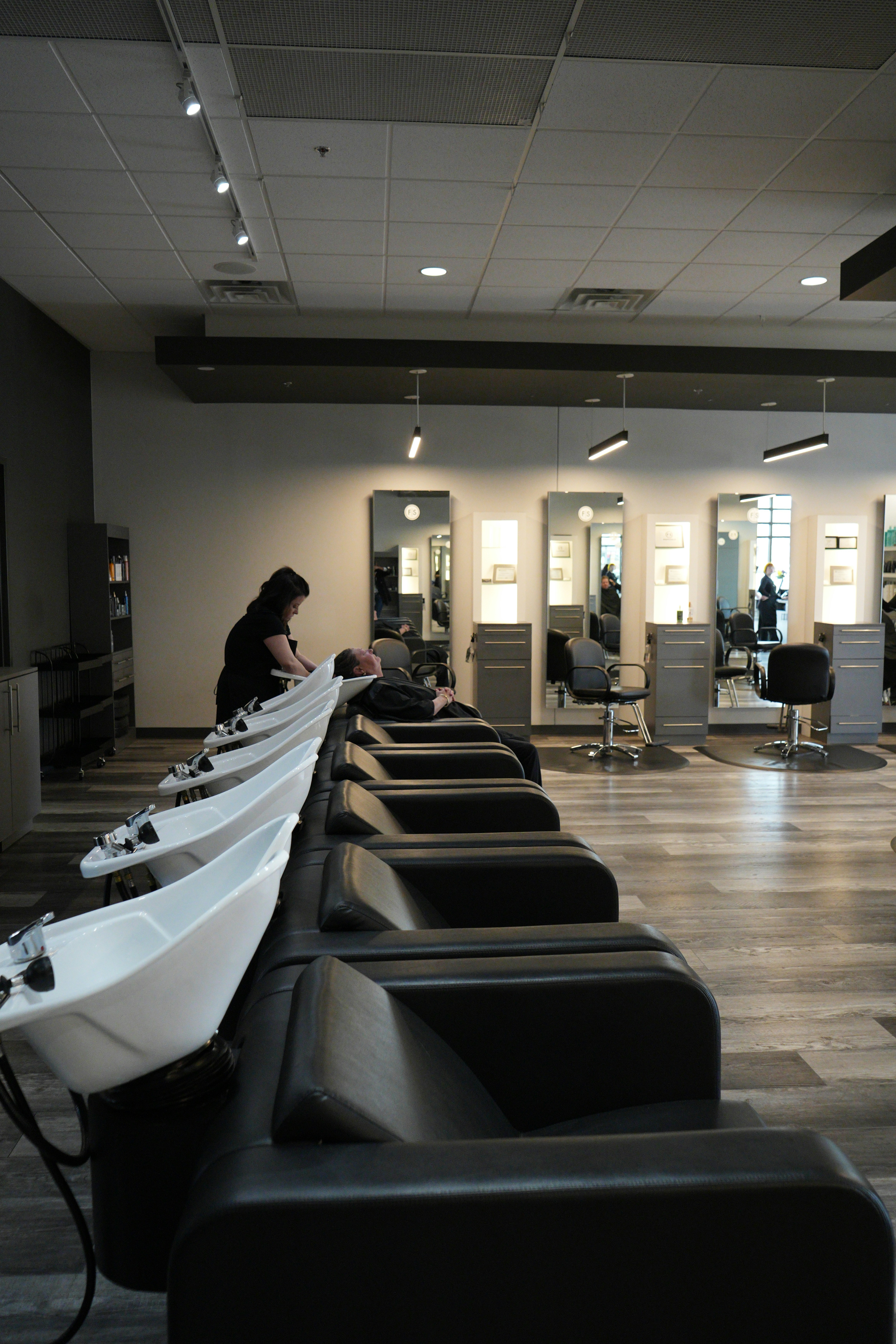 Stylist providing professional care in a salon with dedicated wash stations