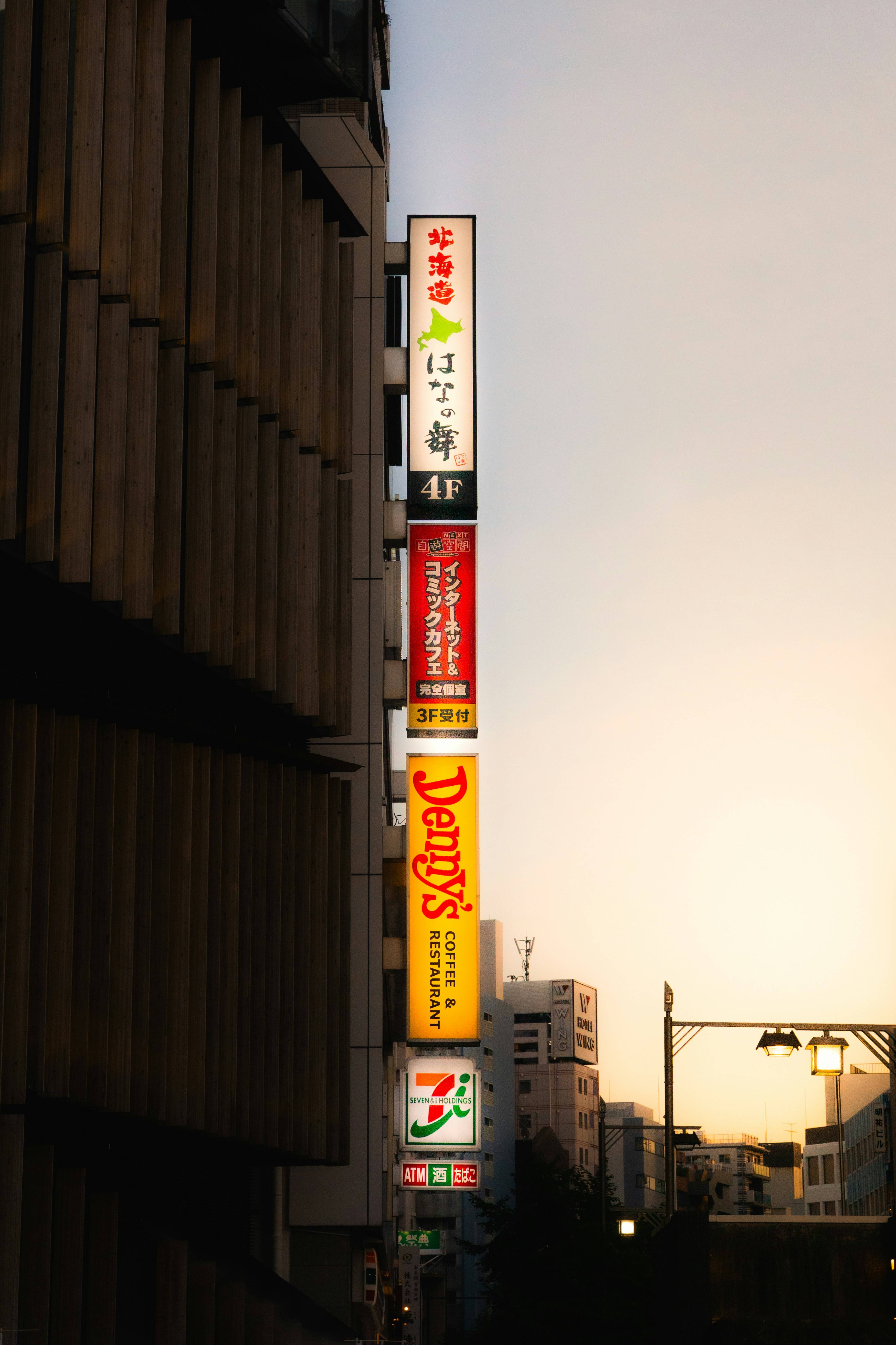 Street signs light up against the evening sky.