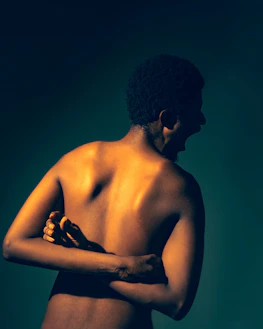 A person screams with arms crossed behind their back.