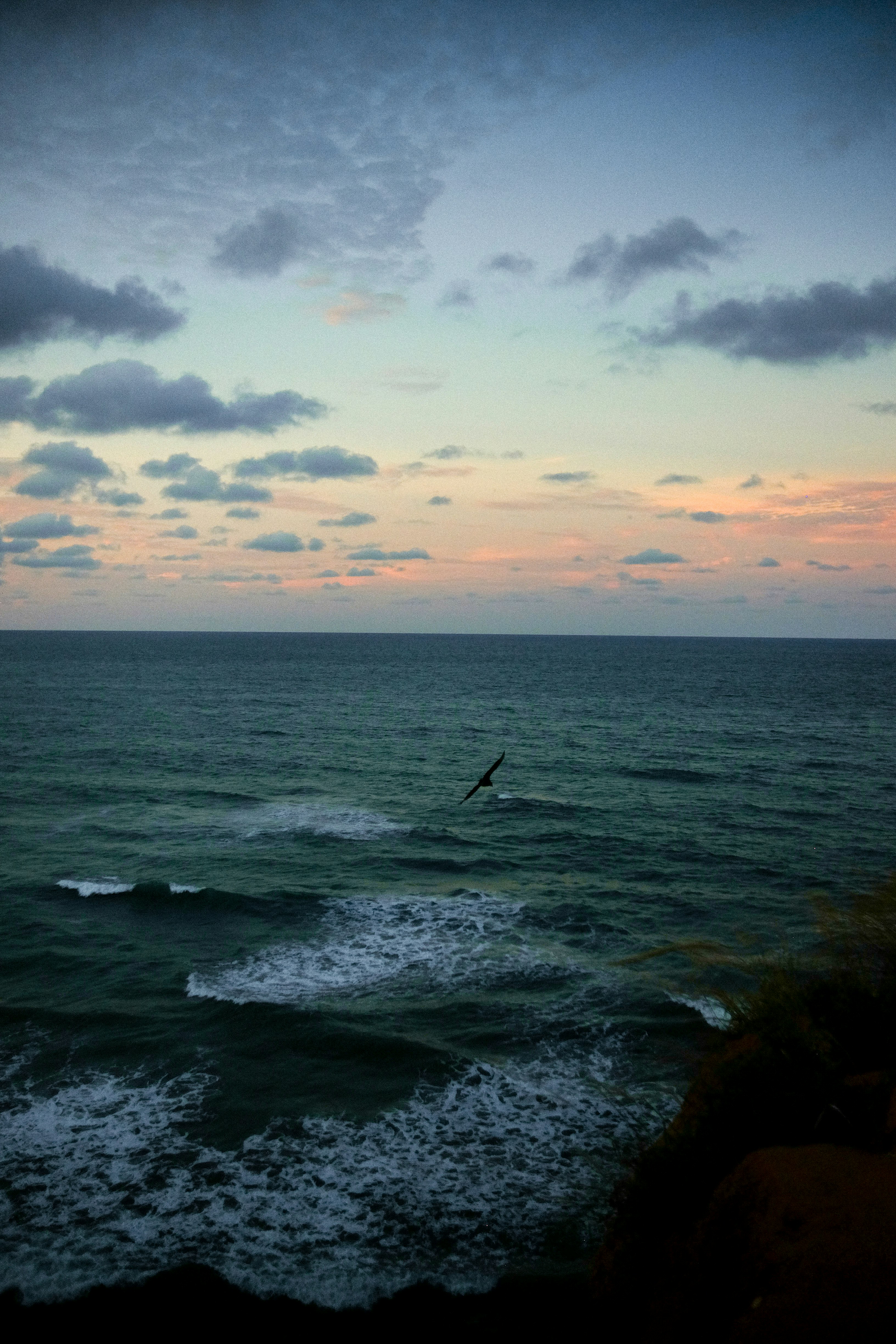 Ocean waves under a colorful sky.