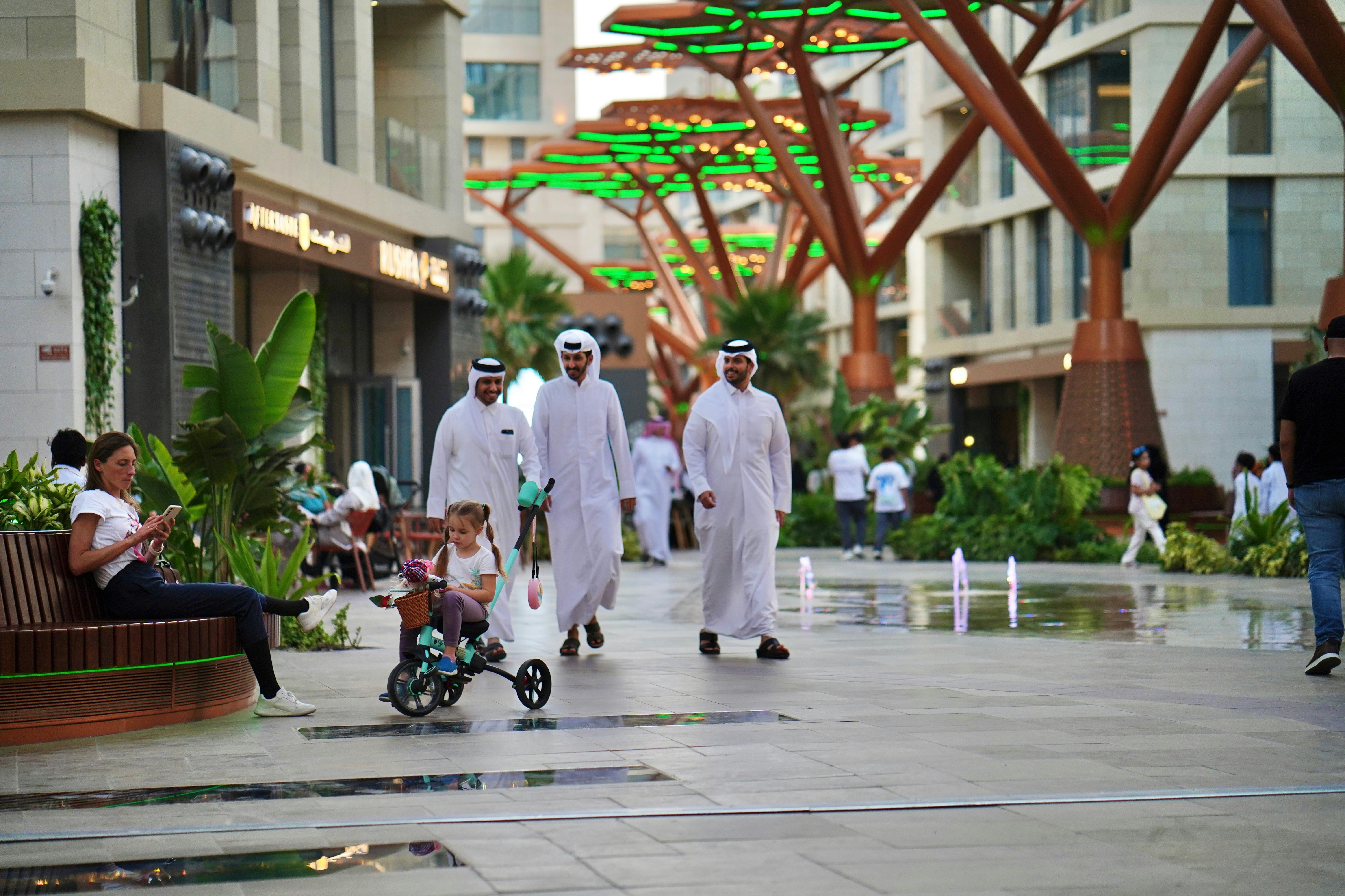 People stroll through a modern outdoor shopping area.
