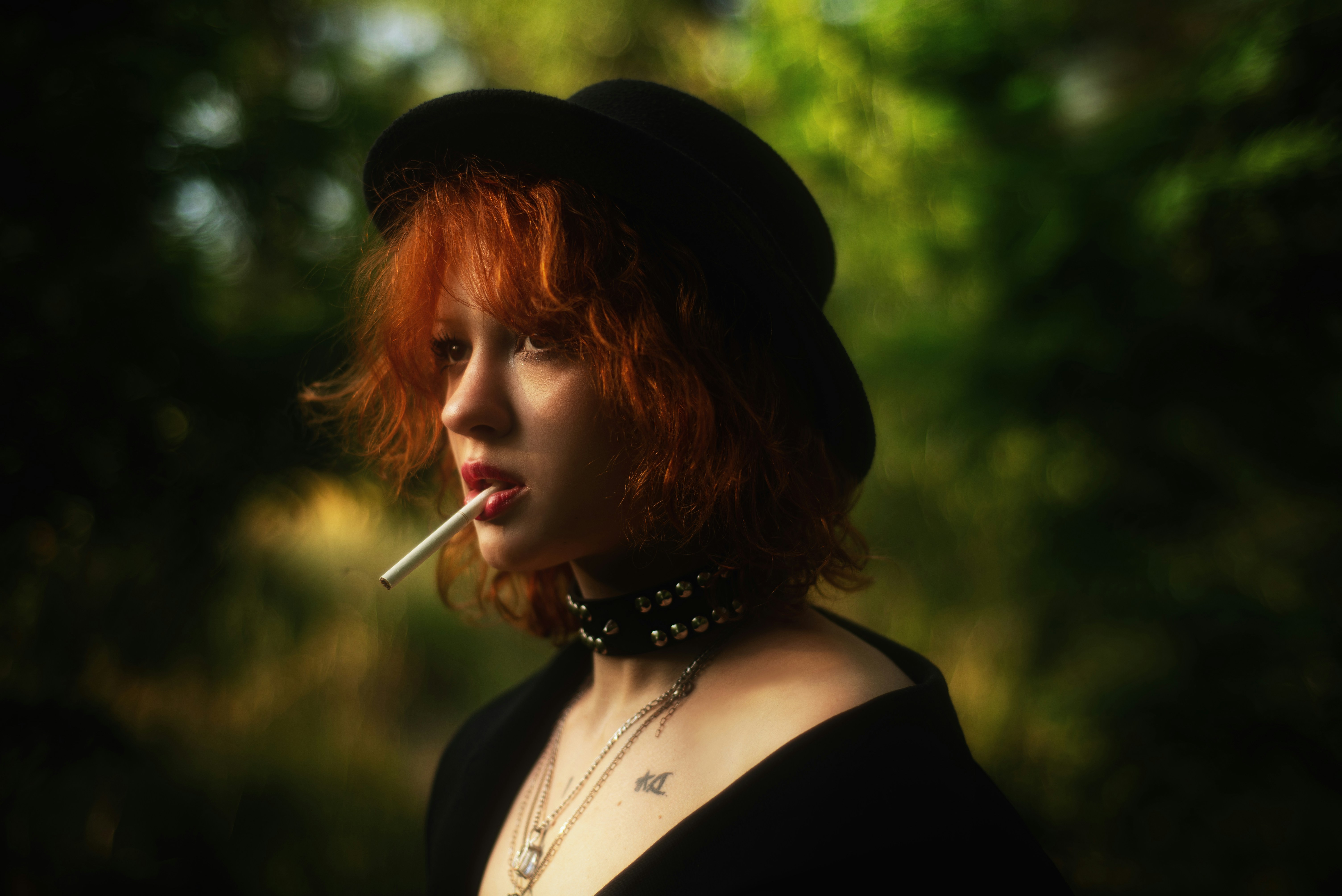 A woman with red hair is smoking.