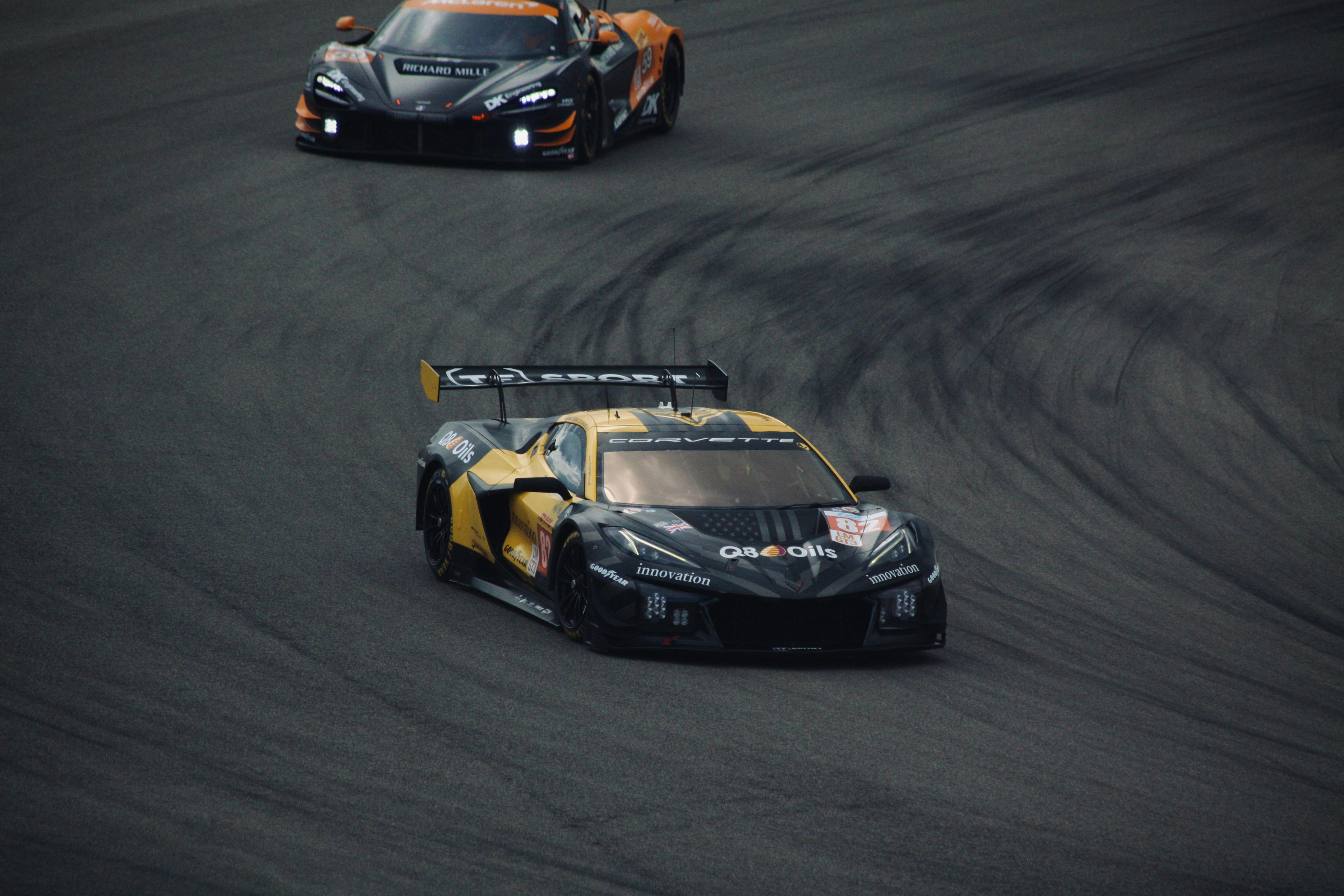 Race cars speed around a track.