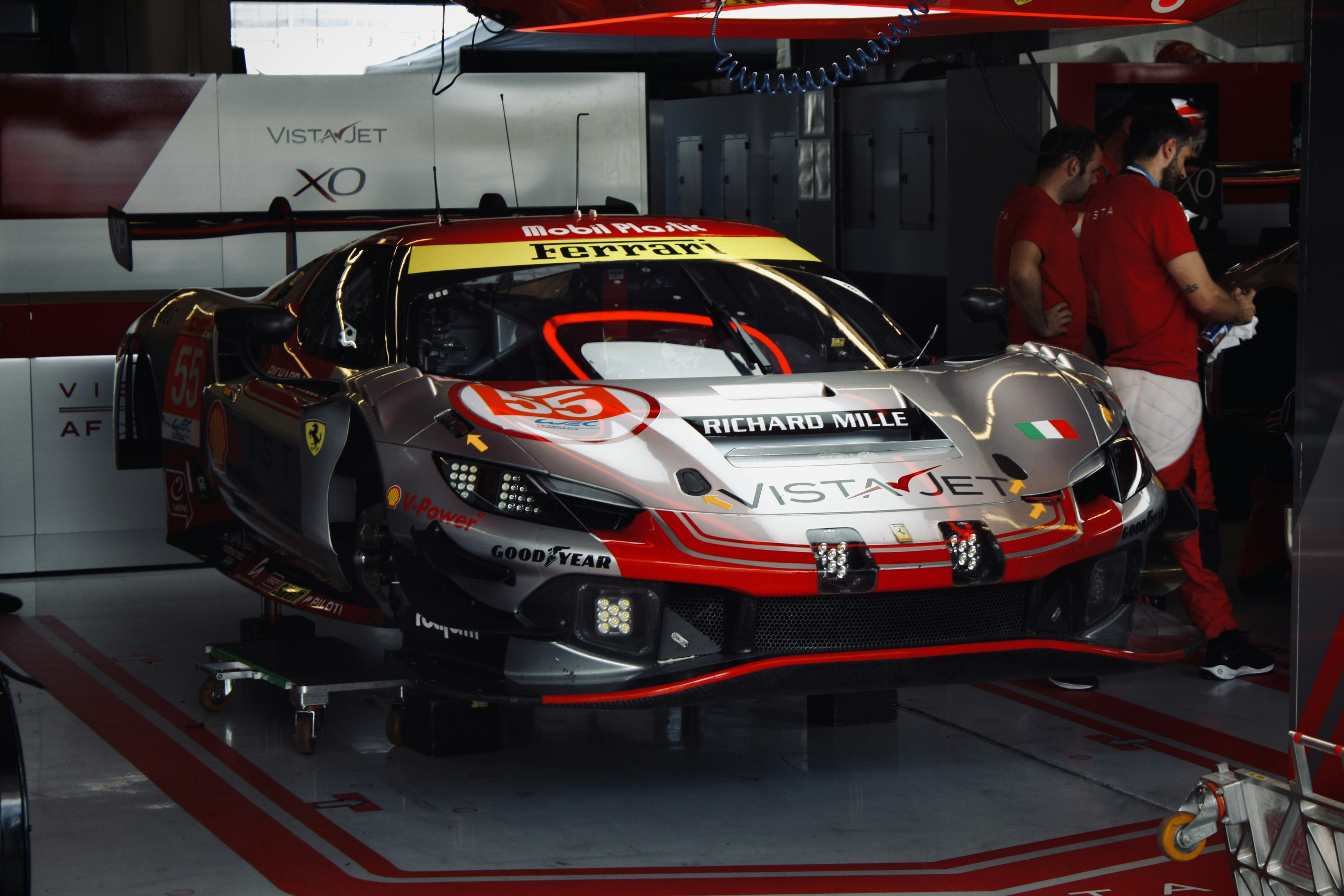 A ferrari race car sits in a garage.